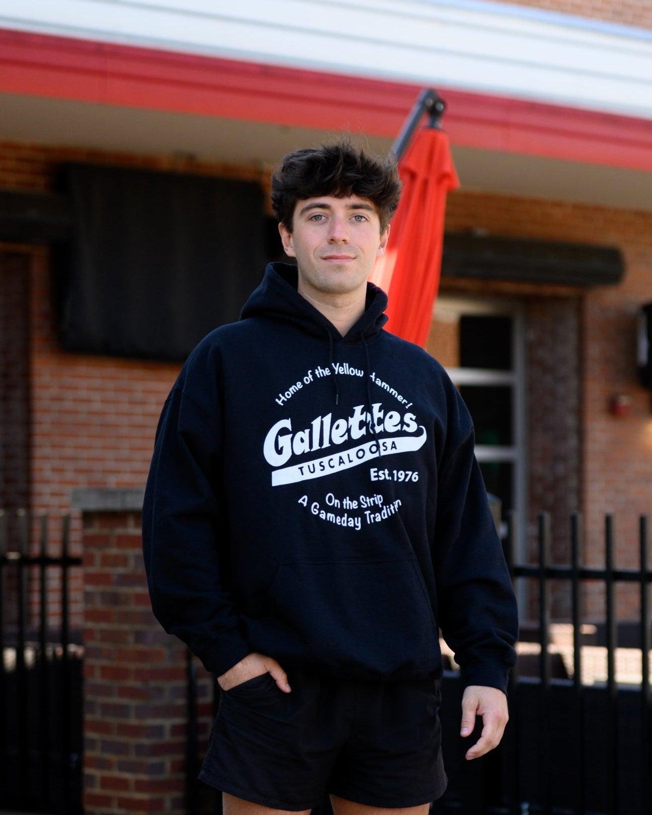 Gallettes Black Hoodie with a White Gallettes logo surrounded by White text "Home of the Yellow Hammer!" and "On the Strip- A Gameday Tradition"