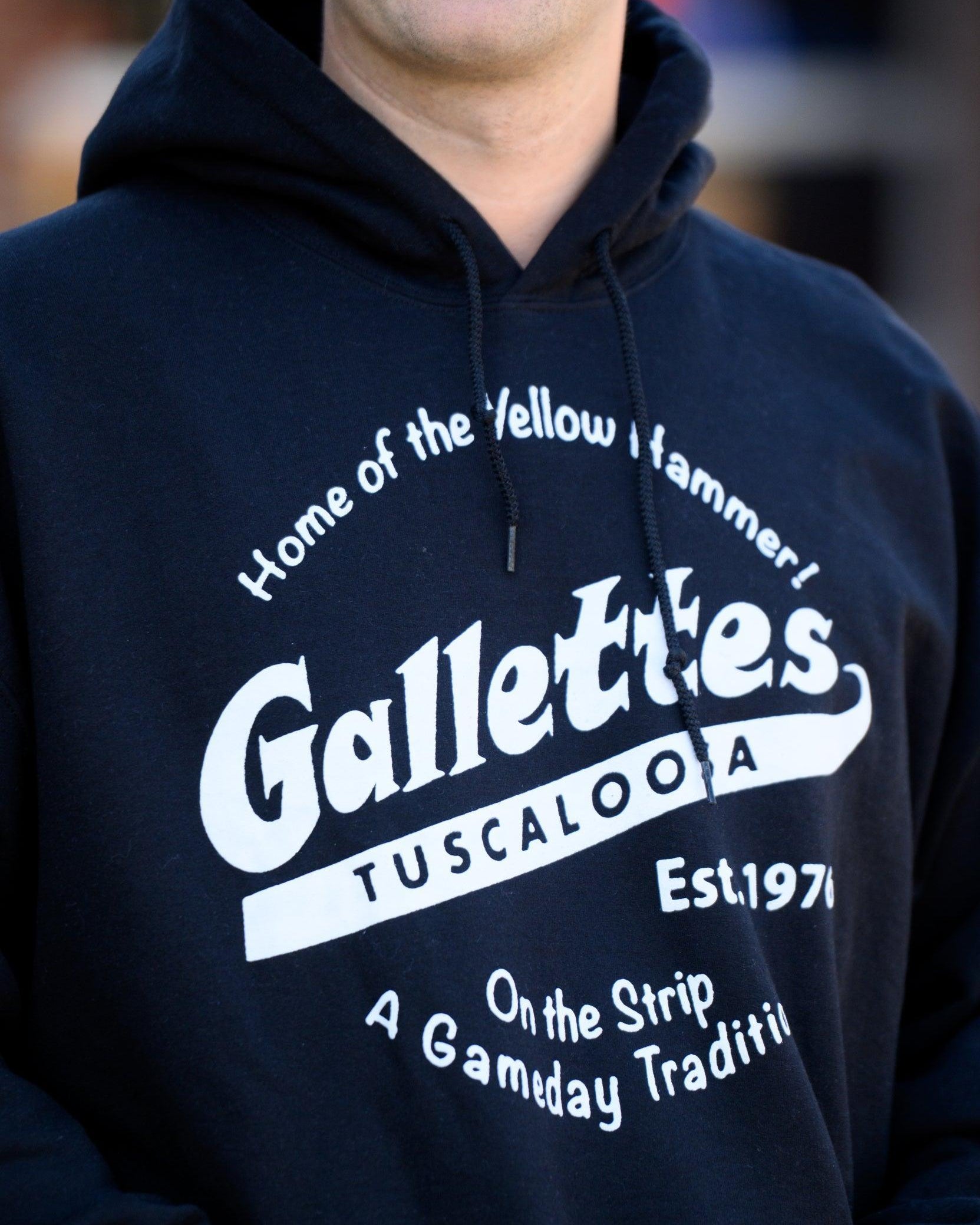 Gallettes Black Hoodie with a White Gallettes logo surrounded by White text "Home of the Yellow Hammer!" and "On the Strip- A Gameday Tradition"
