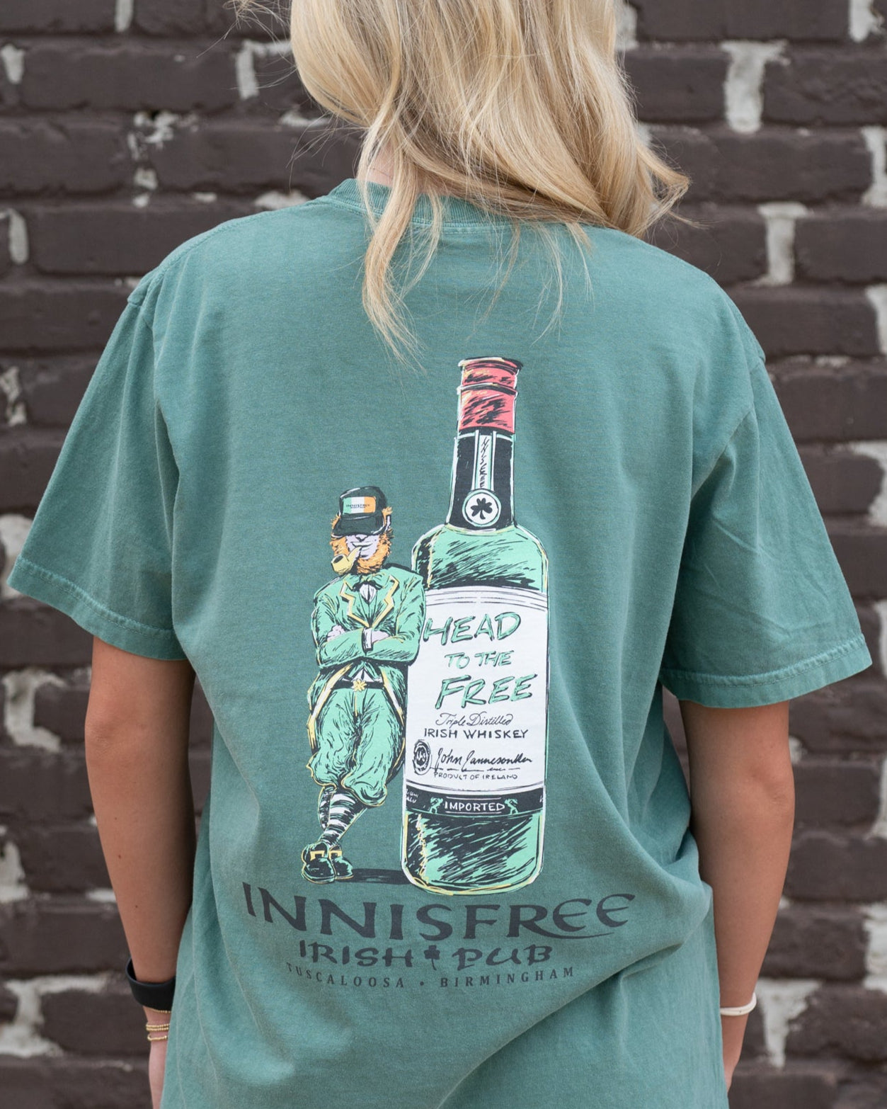 Innisfree Green T-Shirt with a hand-drawn design featuring a leprechaun leaning against a bottle and the text 'INNISFREE Irish Pub' on the back.
