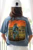 Auburn University Blue T-Shirt with an image of Aubie wearing cowboy clothes and watching over cattle at sunrise above Black text “Home on the Plains”