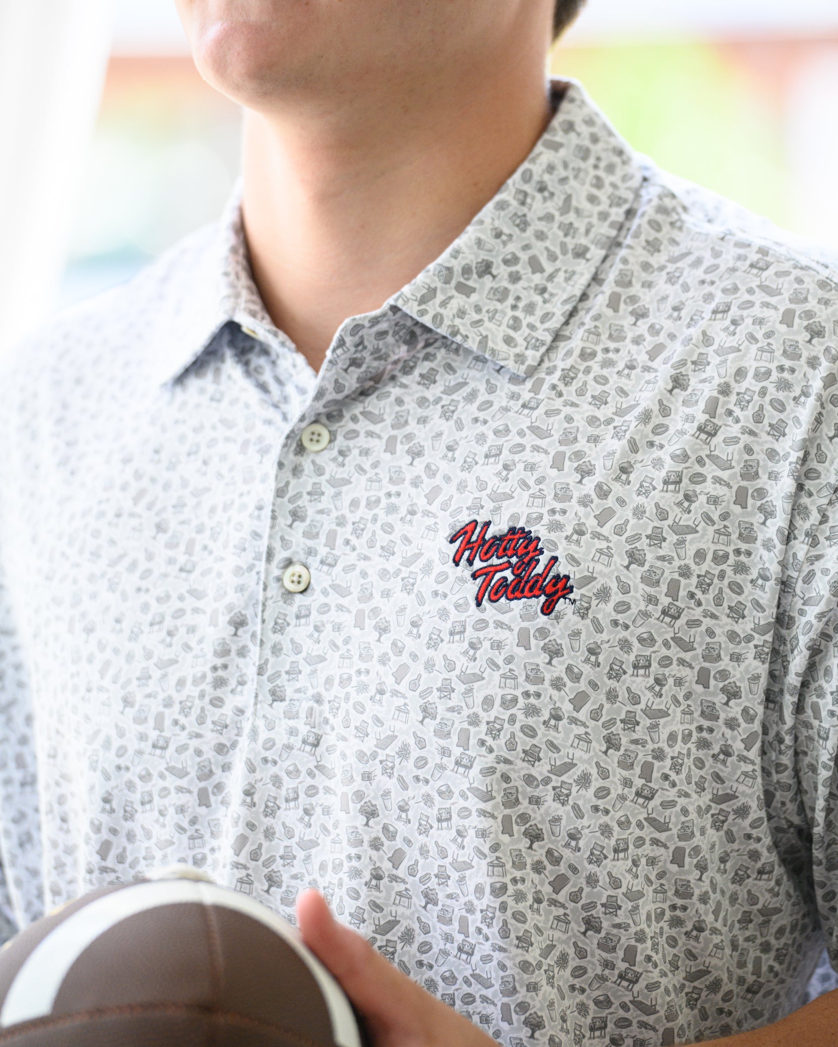 Ole Miss Grey Men’s Patterned Polo with a tailgate themed pattern and Red script “Hotty Toddy” embroidery