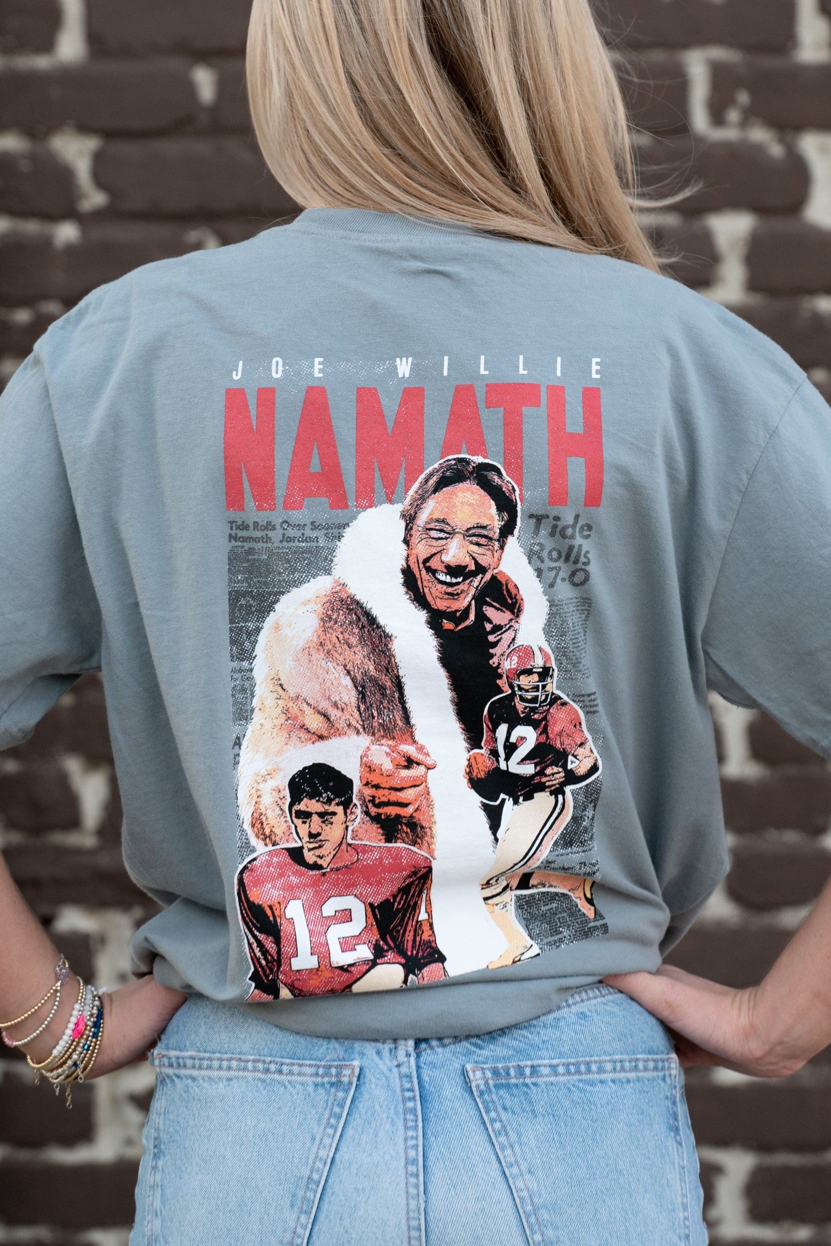 University of Alabama Grey Namath T-Shirt with a graphic design of Joe Willie Namath, featuring images of Namath playing football and holding a trophy.