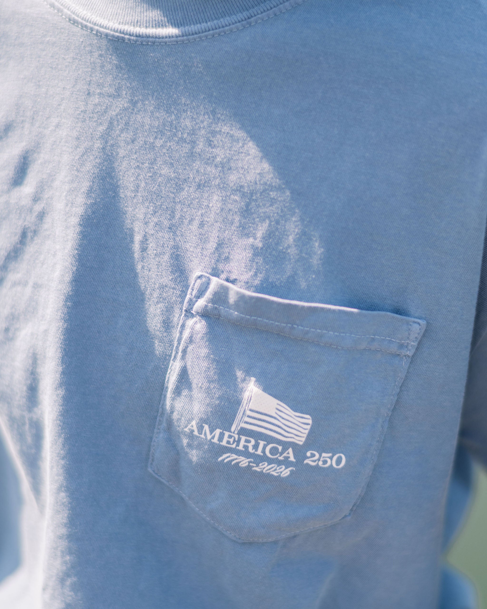 Front Pocket with an American flag waving over text “America 250- 1776-2026”