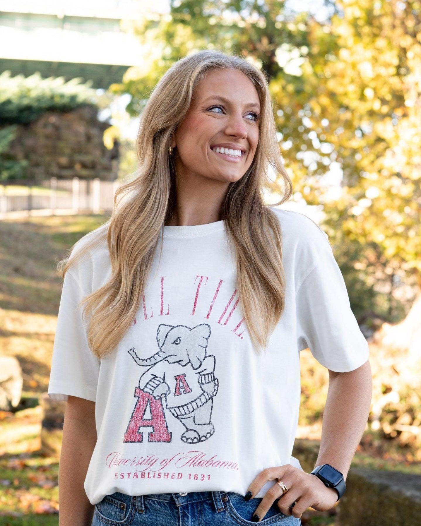 University of Alabama Ivory T-Shirt with Red text “Roll Tide” above an image of Big Al leaning on a Black A