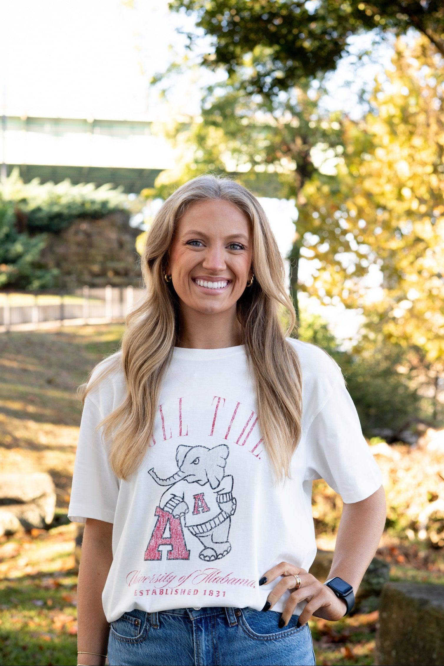 University of Alabama Ivory T-Shirt with Red text “Roll Tide” above an image of Big Al leaning on a Black A