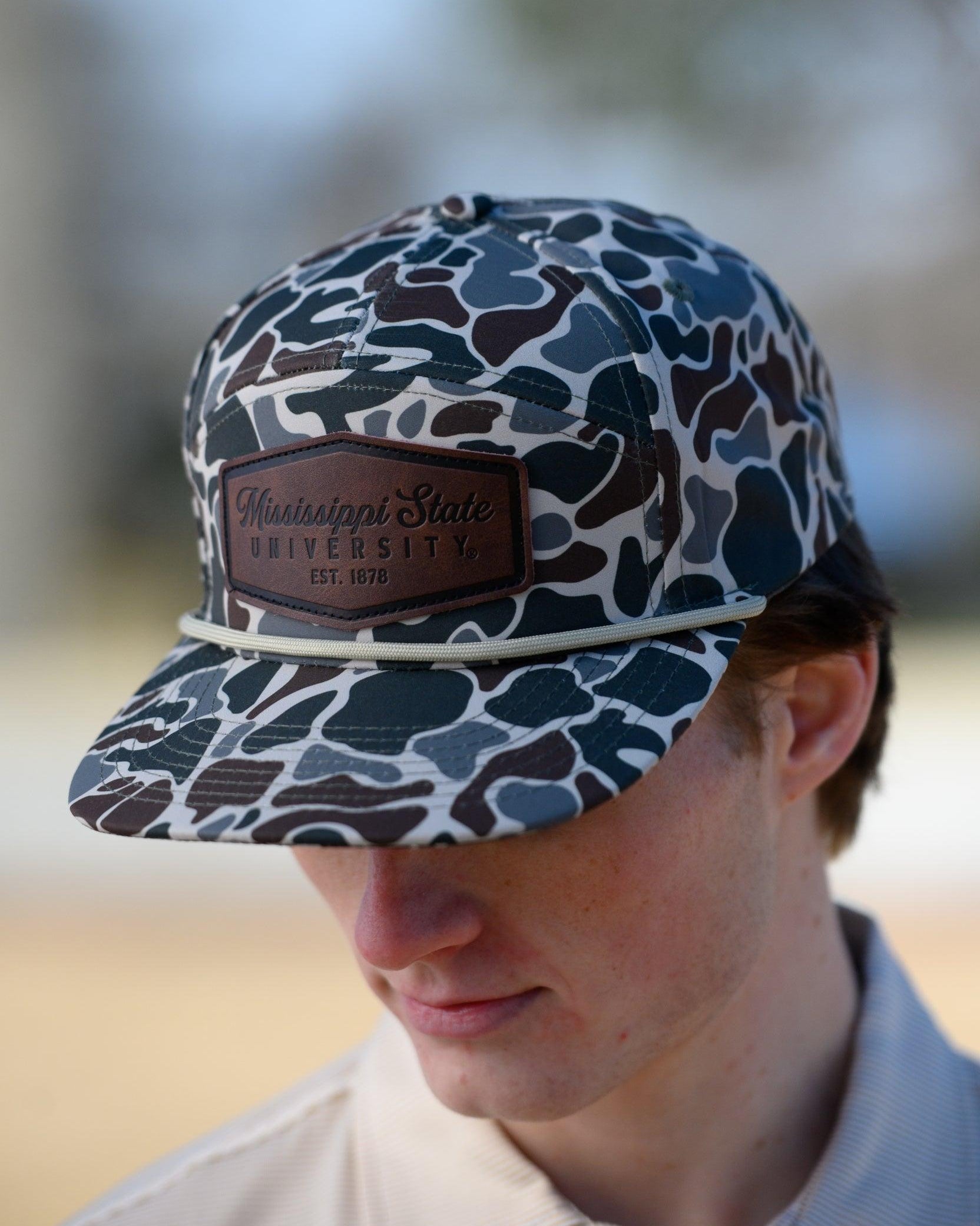 Mississippi State Camo Hat with a White rope and a leather patch with text “Mississippi State University”
