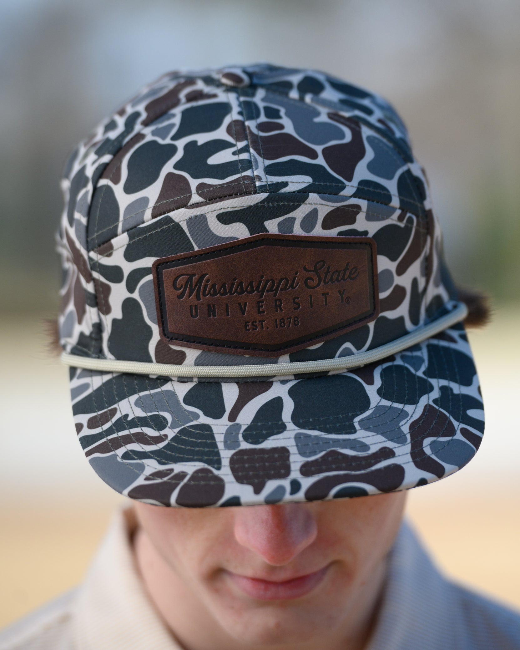 Mississippi State Camo Hat with a White rope and a leather patch with text “Mississippi State University”