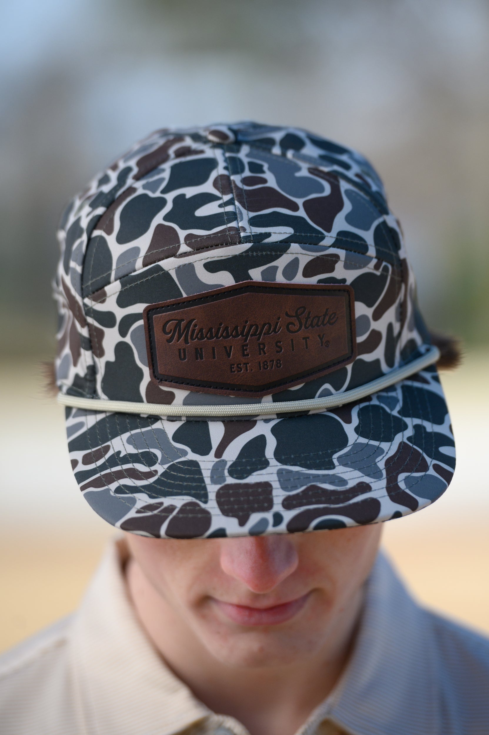 Mississippi State Camo Hat with a White rope and a leather patch with text “Mississippi State University”
