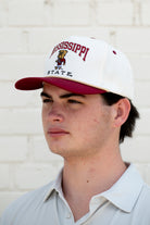 Mississippi State Cream and Maroon Hat with the Walking Bully Logo in between embroidered text “Mississippi State”