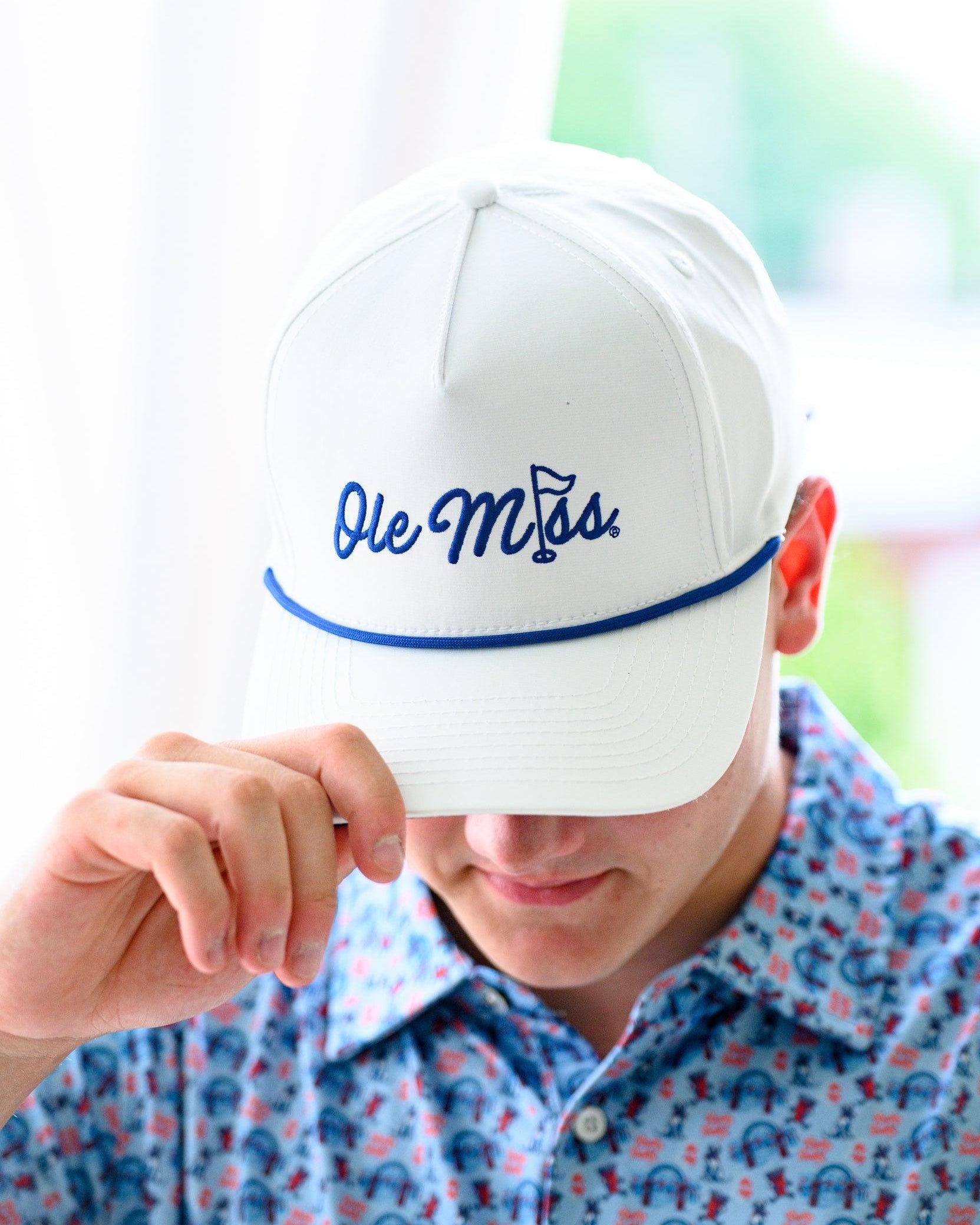 Ole Miss White Hat with Blue embroidery “Ole Miss” with a golf flag representing the “I” in “Miss”