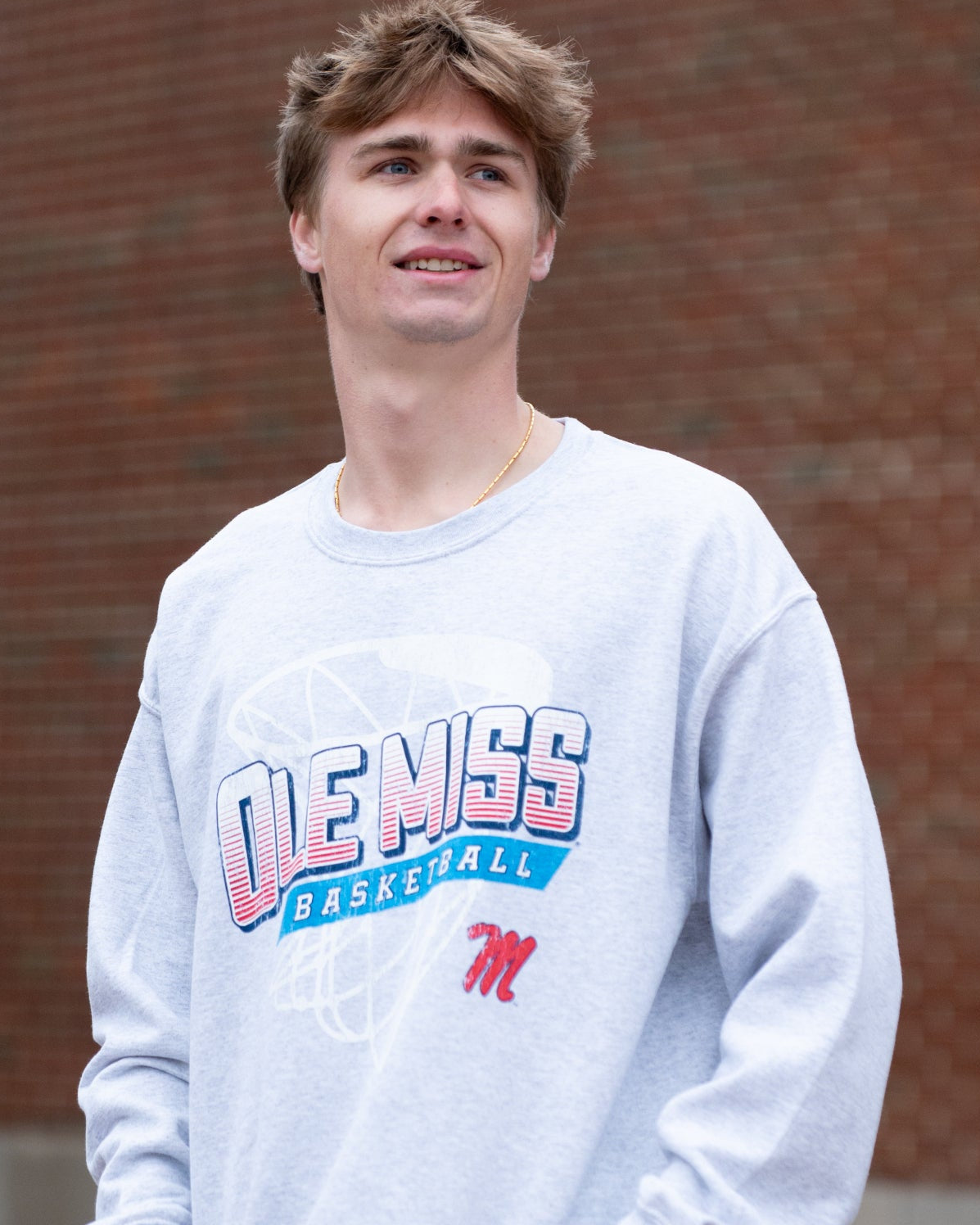 Ole Miss Light Grey Heather Sweatshirt with a basketball hoop outline behind text “Ole Miss Basketball”