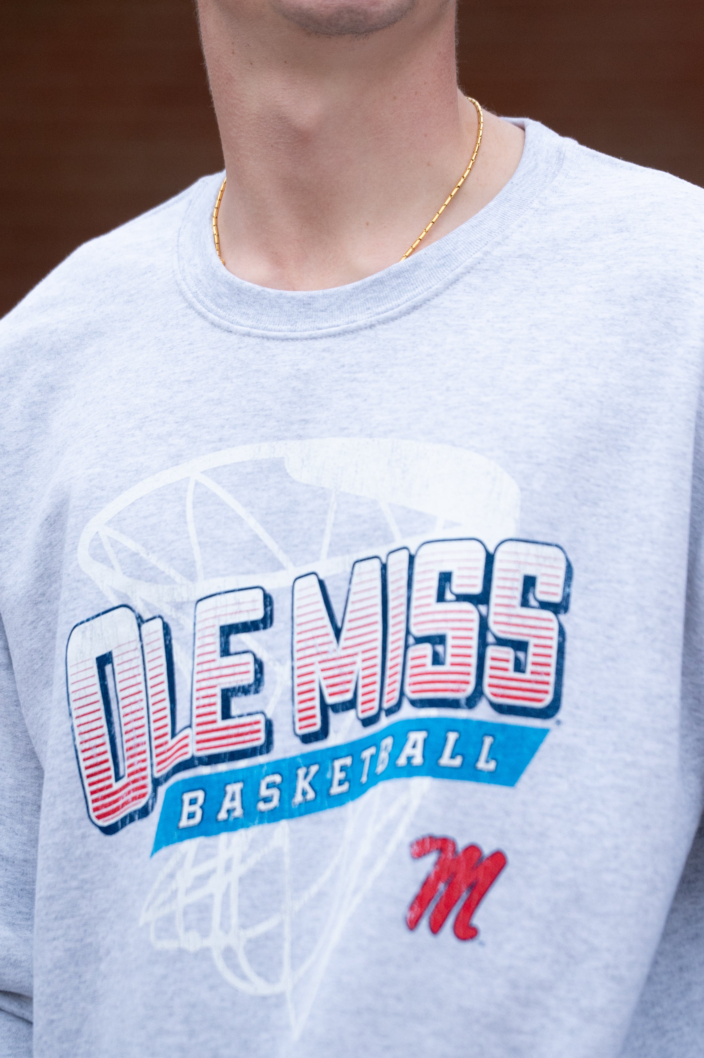 Ole Miss Light Grey Heather Sweatshirt with a basketball hoop outline behind text “Ole Miss Basketball”
