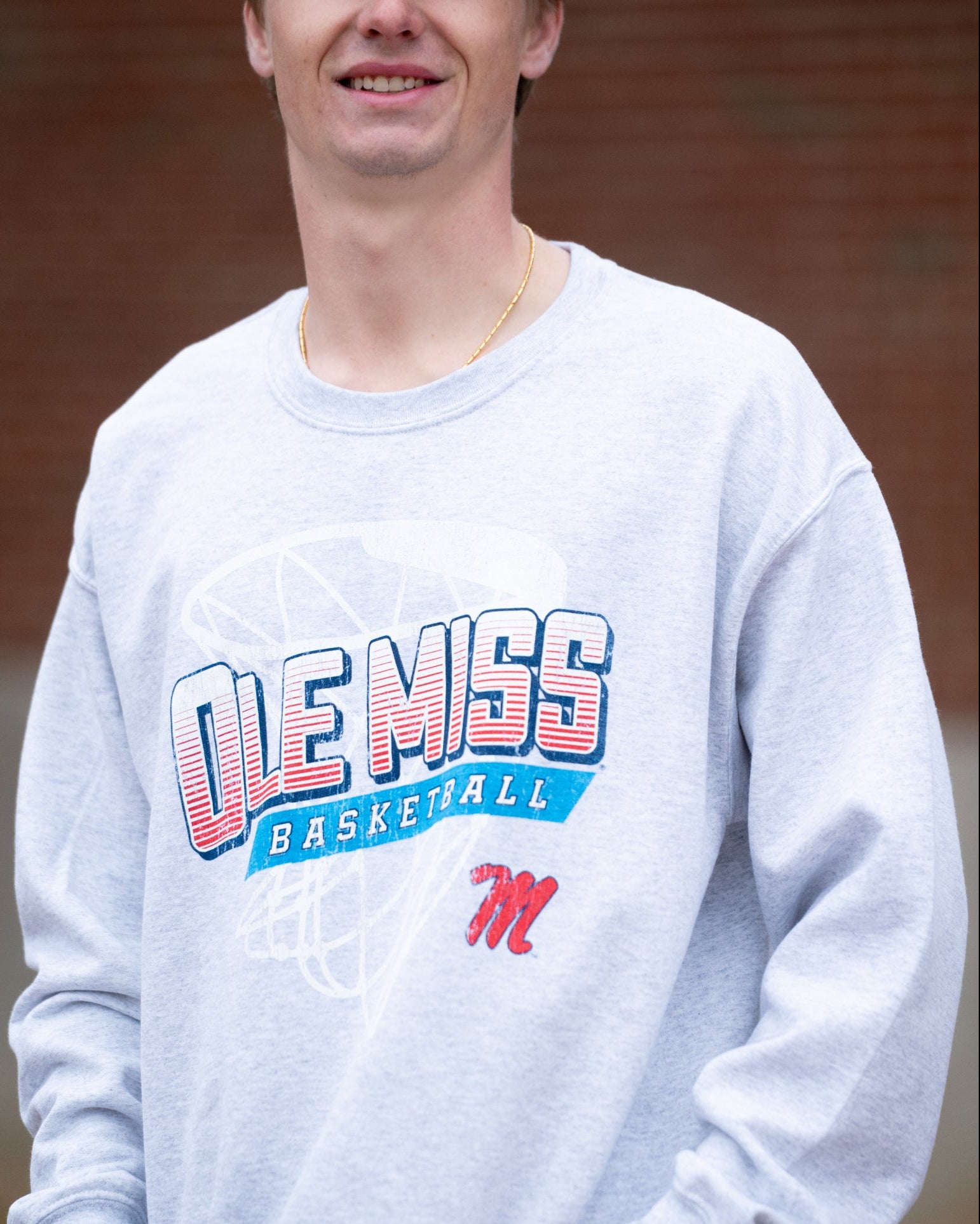 Ole Miss Light Grey Heather Sweatshirt with a basketball hoop outline behind text “Ole Miss Basketball”