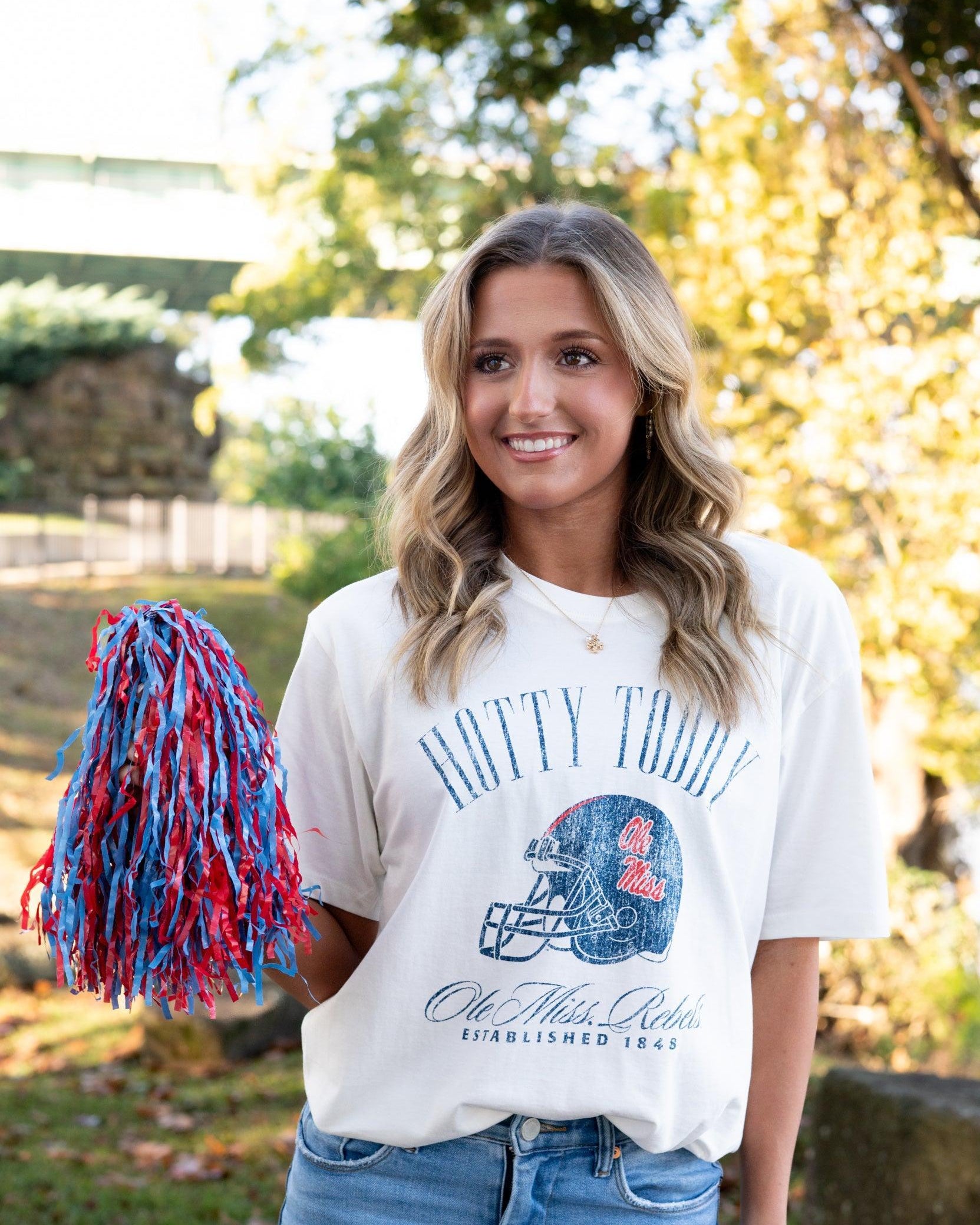 Ole Miss Ivory T-Shirt with Blue text “Hotty Toddy” above an image of a football helmet