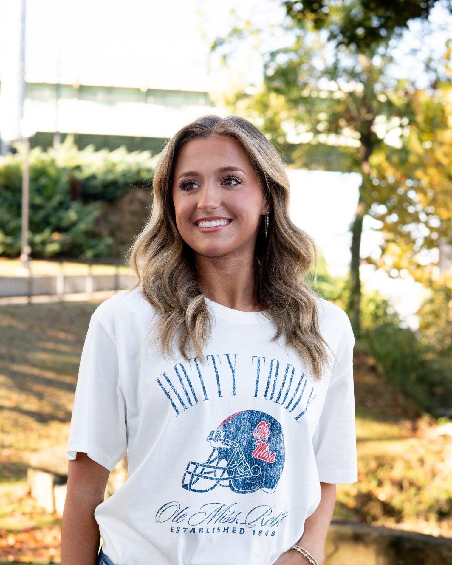 Ole Miss Ivory T-Shirt with Blue text “Hotty Toddy” above an image of a football helmet