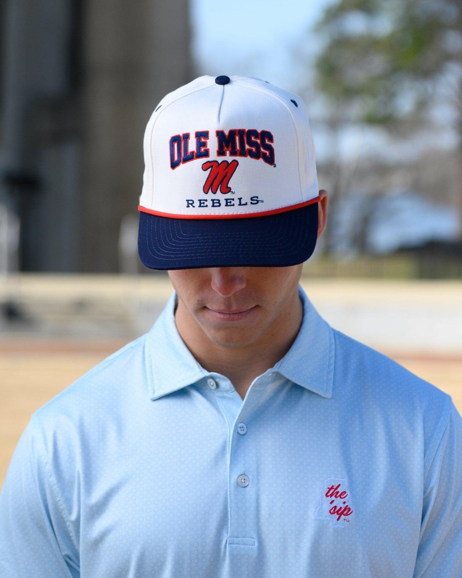 Ole Miss Cream and Navy Hat with embroidered text “Ole Miss Rebels” surrounding the Script M Logo