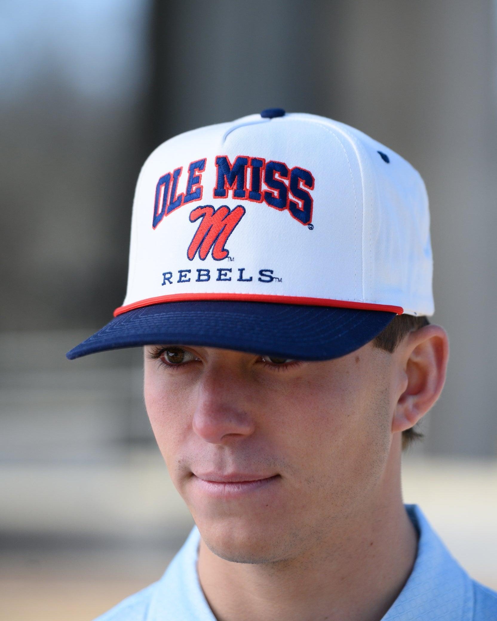 Ole Miss Cream and Navy Hat with embroidered text “Ole Miss Rebels” surrounding the Script M Logo