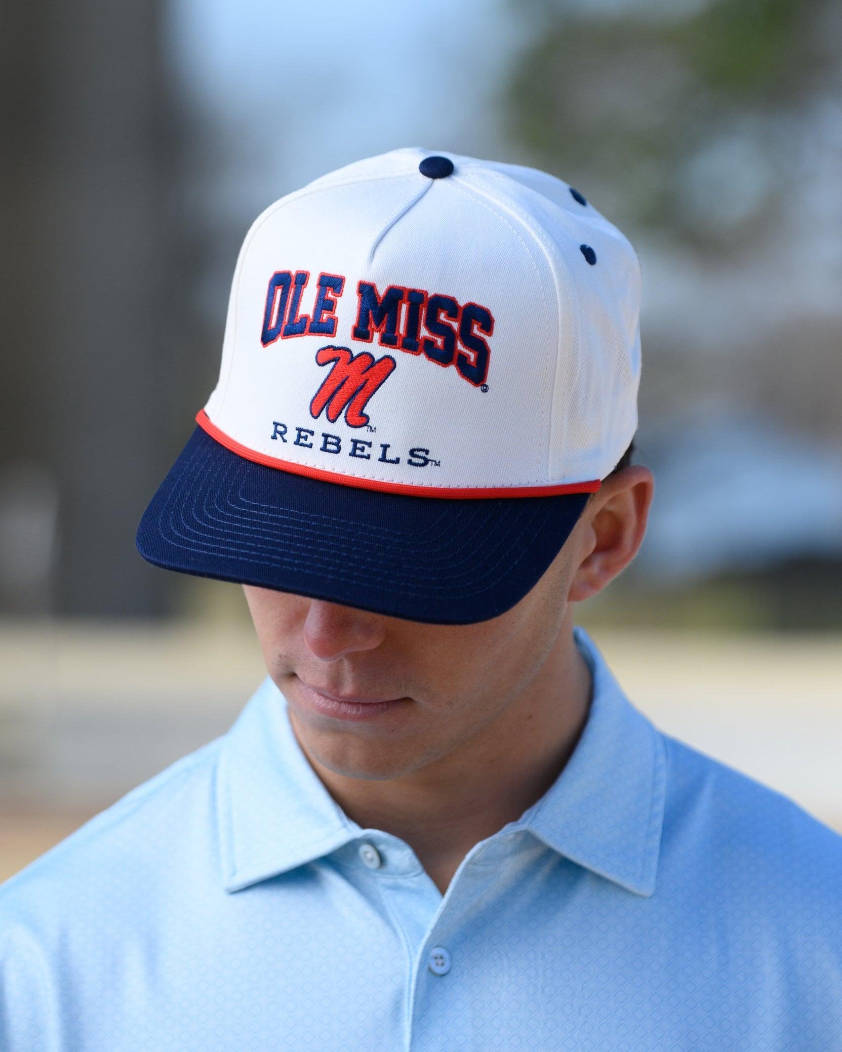 Ole Miss Cream and Navy Hat with embroidered text “Ole Miss Rebels” surrounding the Script M Logo