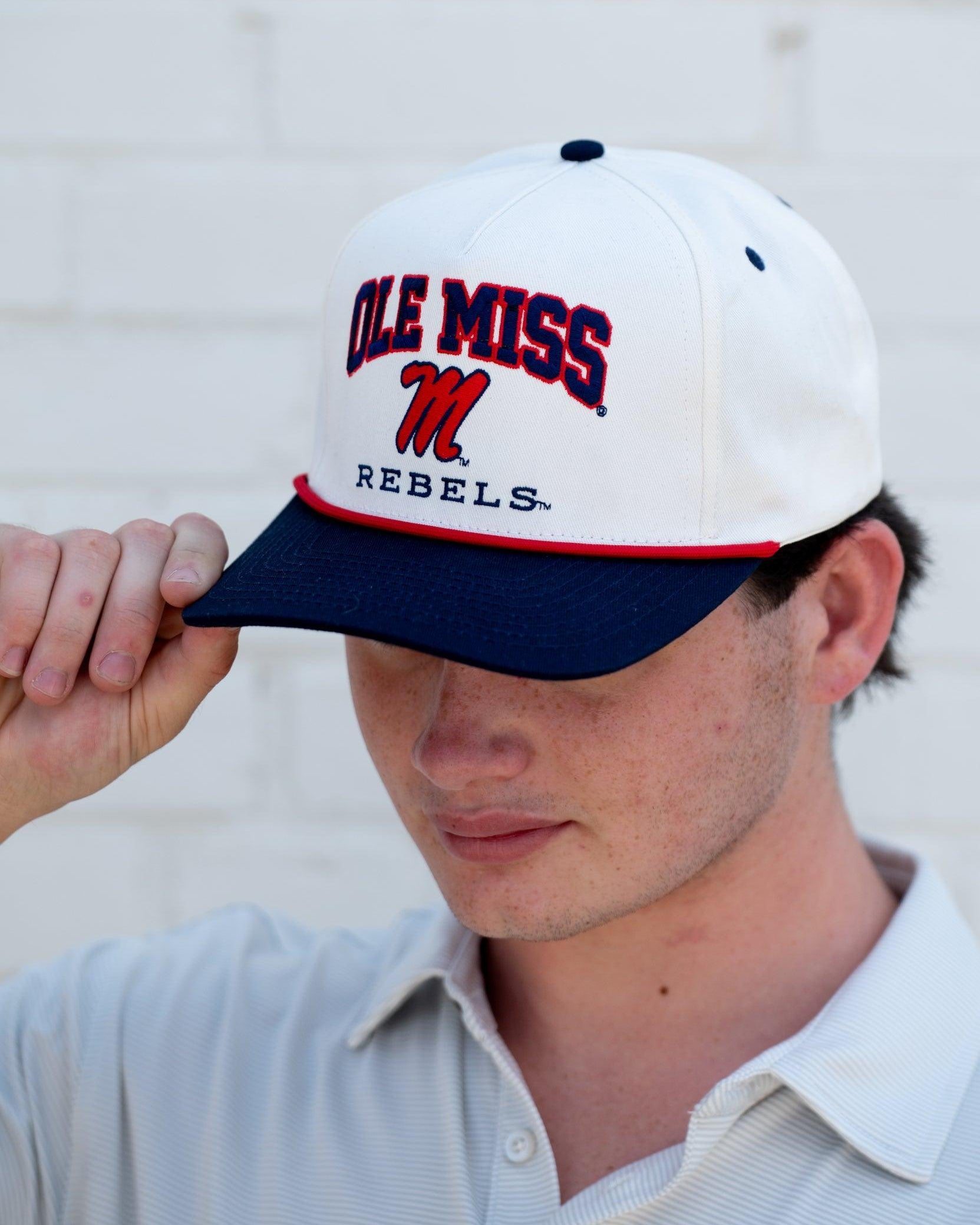 Ole Miss Cream and Navy Hat with embroidered text “Ole Miss Rebels” surrounding the Script M Logo