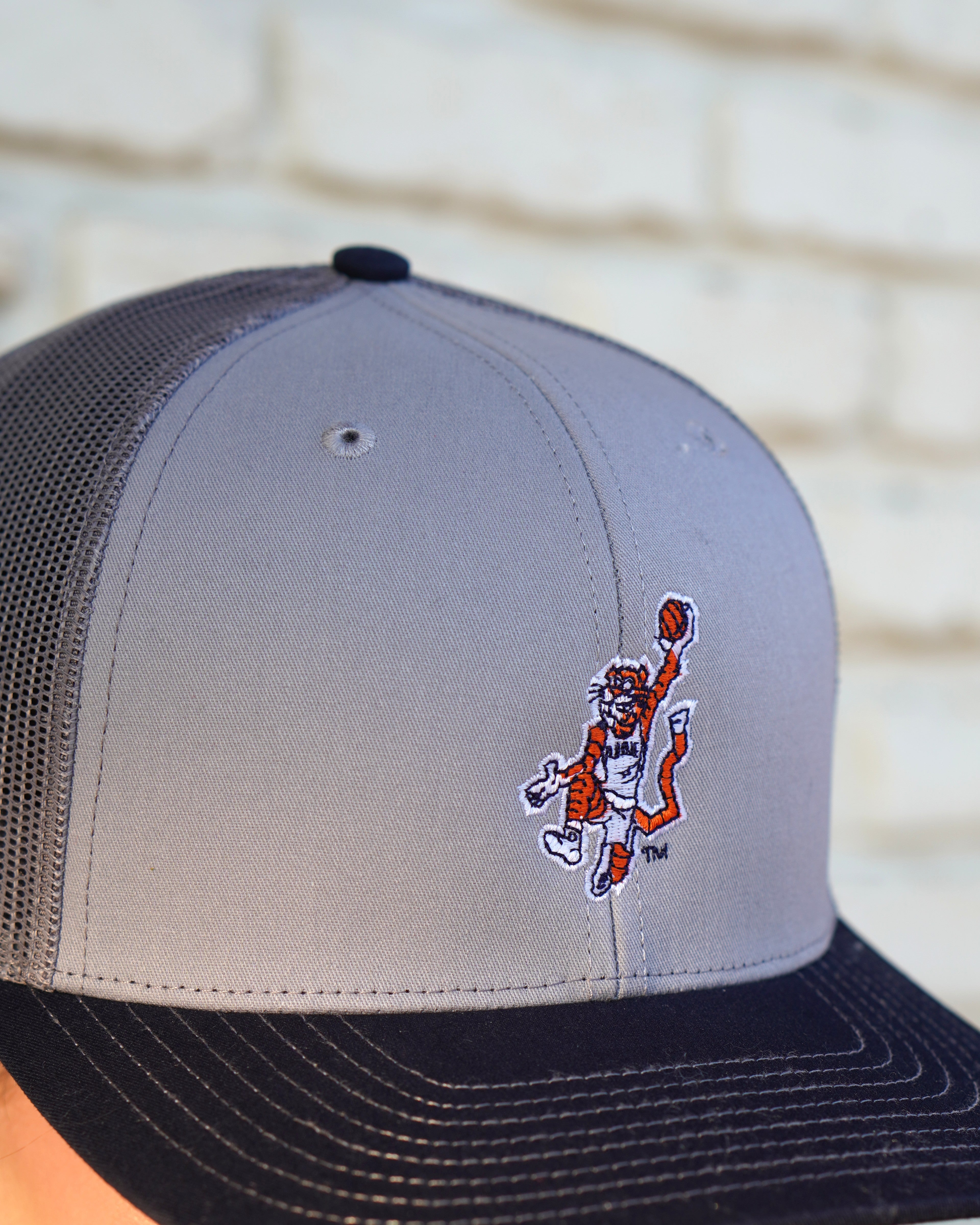 Auburn University Grey and Navy Trucker Hat with the Original Aubie basketball logo on the front, featuring a gray crown and black visor.