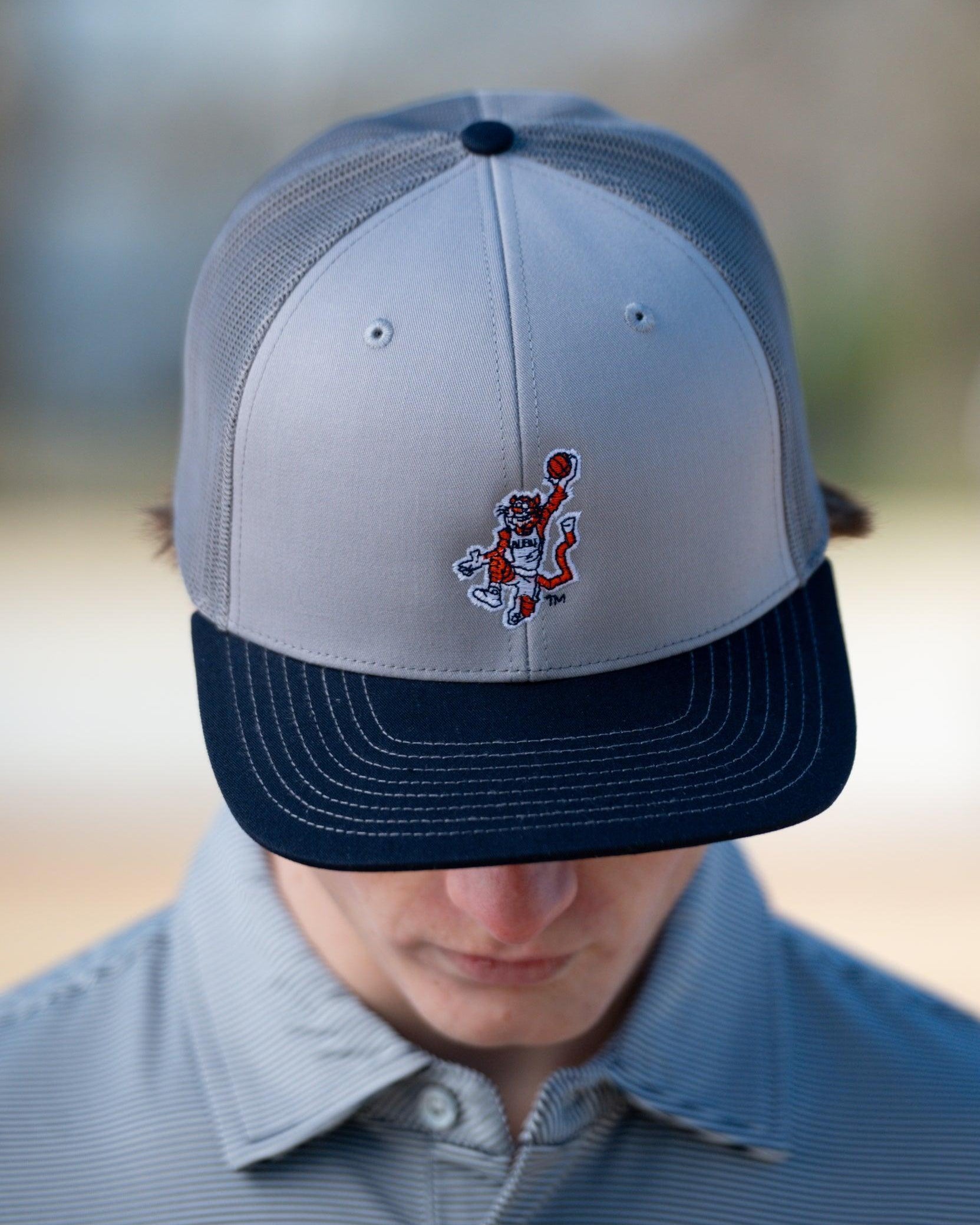 Auburn University Grey and Navy Trucker Hat with the Original Aubie basketball logo on the front, featuring a gray crown and black visor.