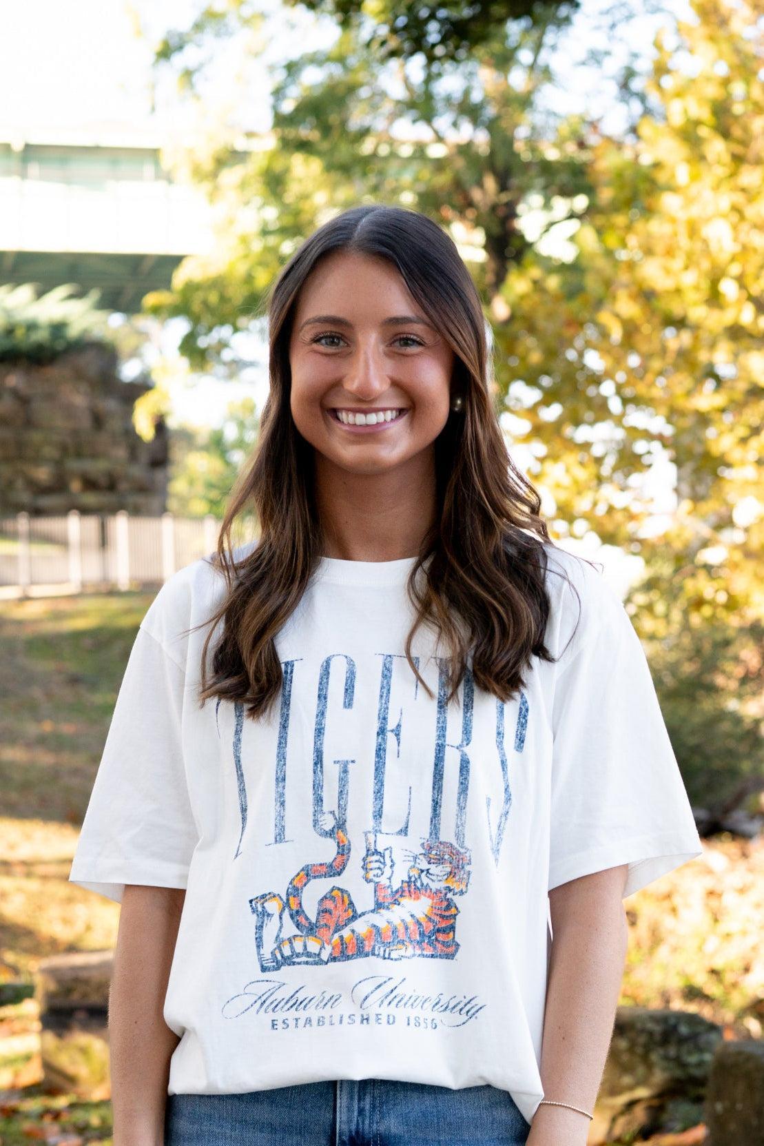 Auburn University Ivory T-Shirt with navy text “Tigers” above Aubie laying down