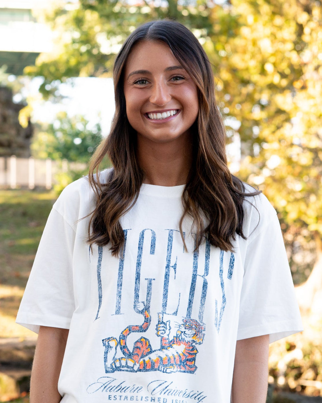 Auburn University Ivory T-Shirt with navy text “Tigers” above Aubie laying down