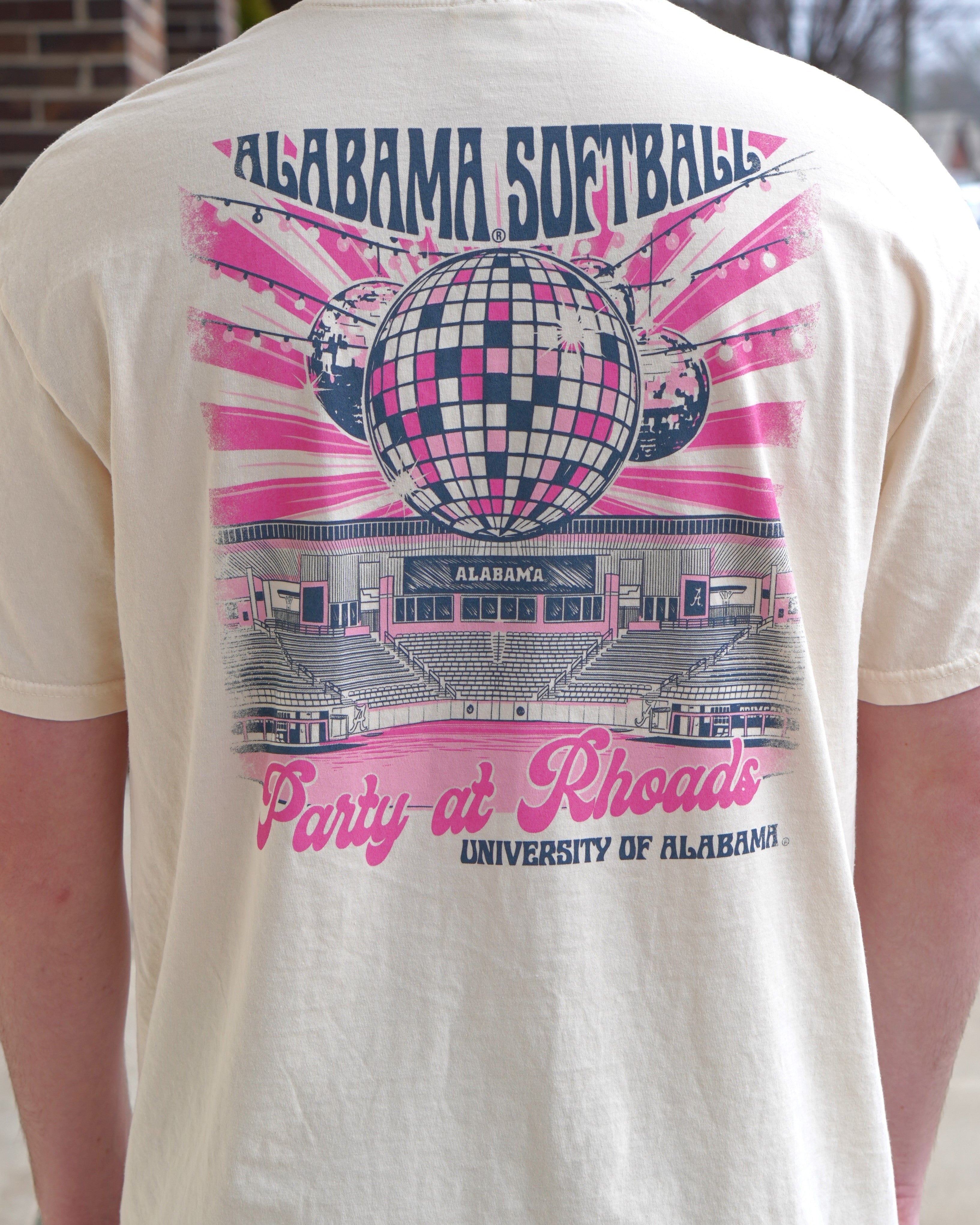 University of Alabama Ivory Ladies' T-Shirt with a hand-drawn design featuring Rhoads Stadium, disco balls, and the color pink, related to the Alabama Softball team.