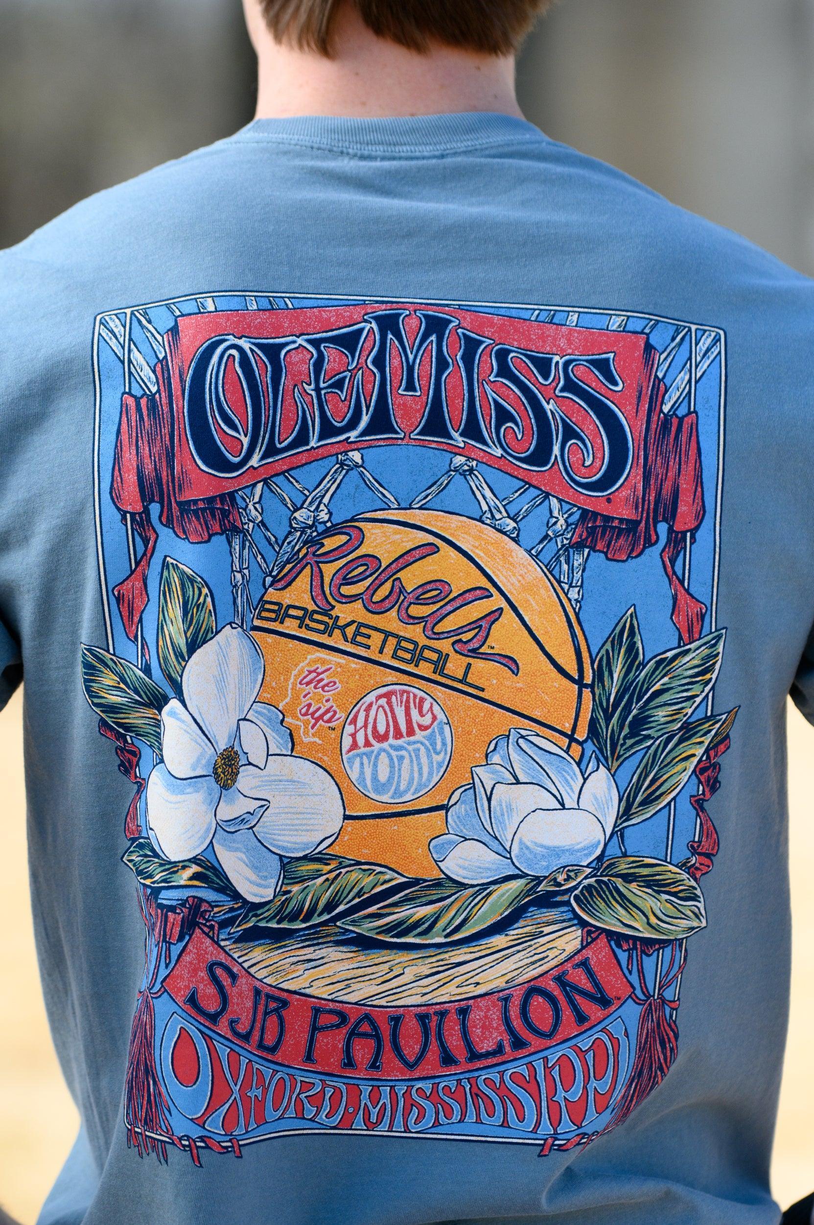 Ole Miss Dusty Light Blue T-Shirt with a basketball card style design featuring a basketball with magnolia flowers in between text “Ole Miss” and “SJB Pavilion”