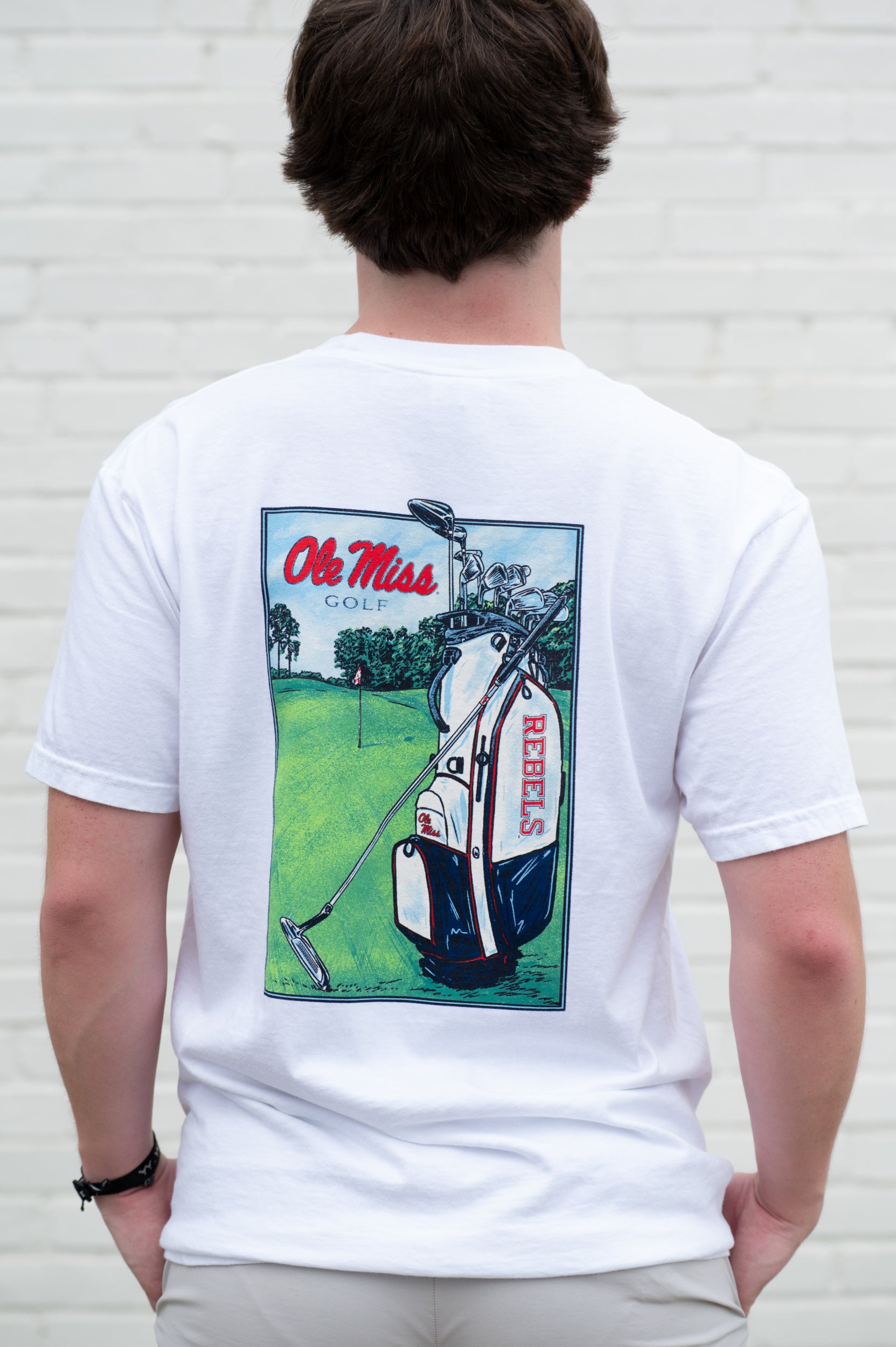 Ole Miss White T-Shirt with an image of a golf club carrying bag with the Rebels Logo