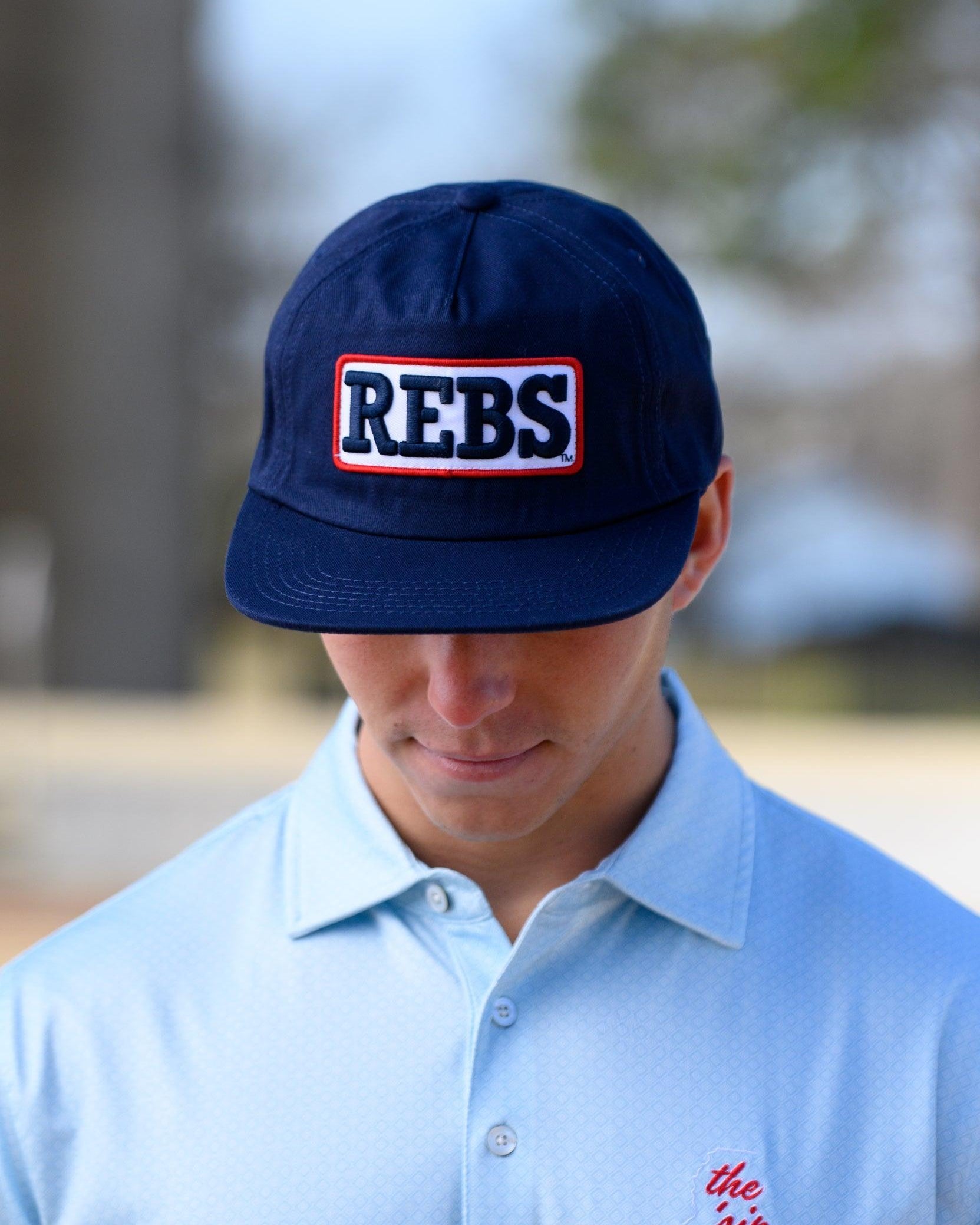 Ole Miss Navy Snapback Hat featuring a White patch with Navy “REBS” embroidery