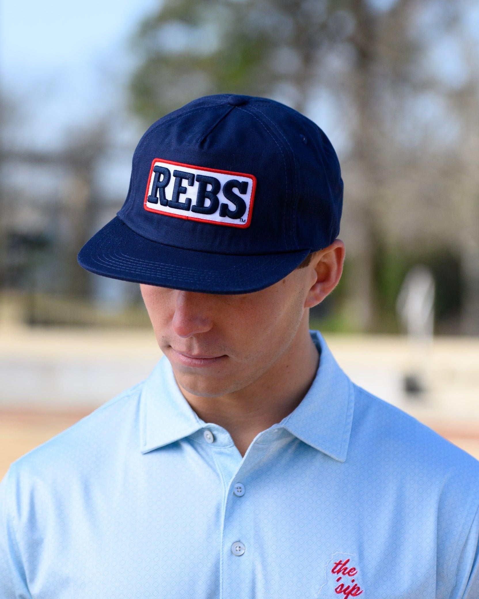 Ole Miss Navy Snapback Hat featuring a White patch with Navy “REBS” embroidery