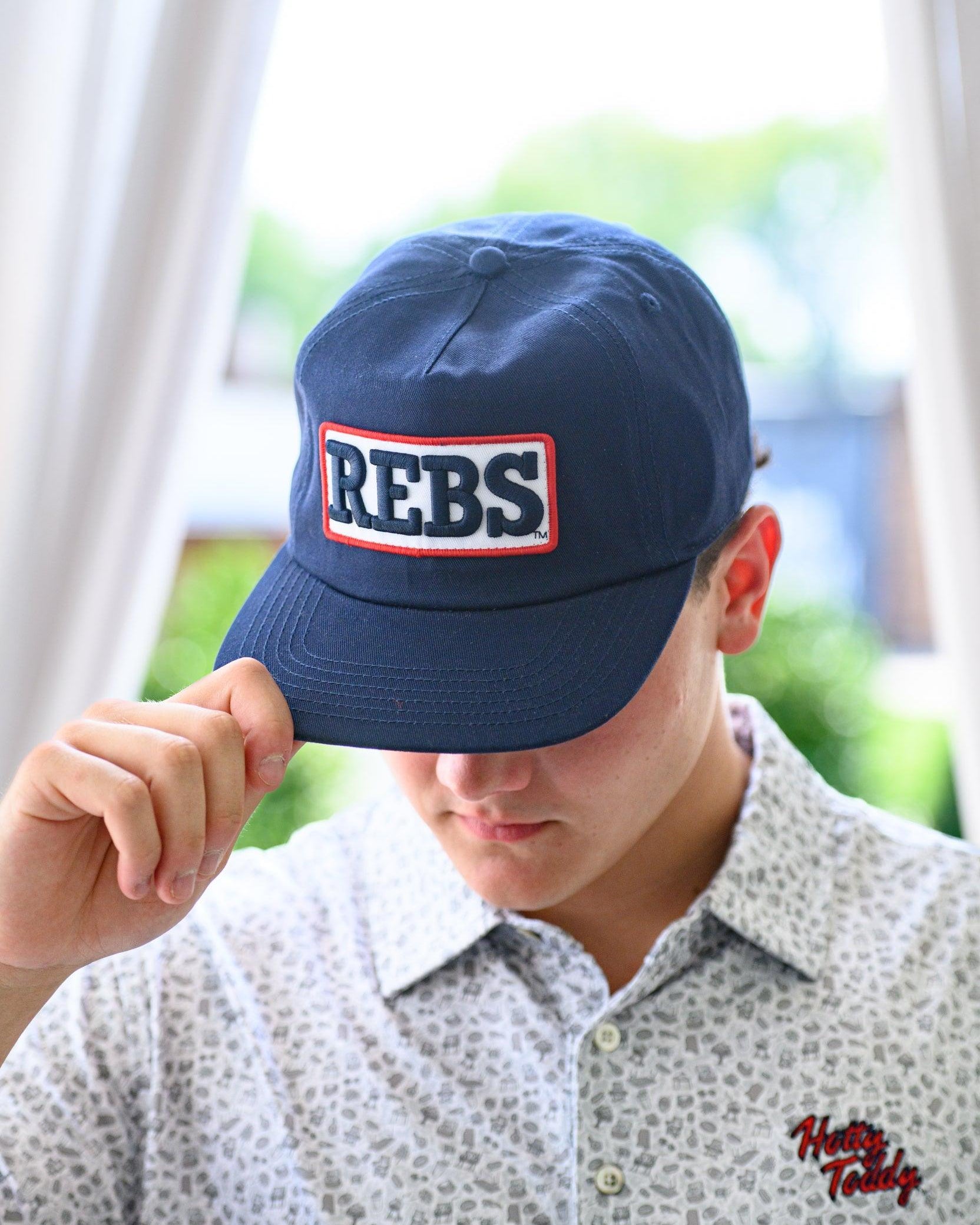 Ole Miss Navy Snapback Hat featuring a White patch with Navy “REBS” embroidery
