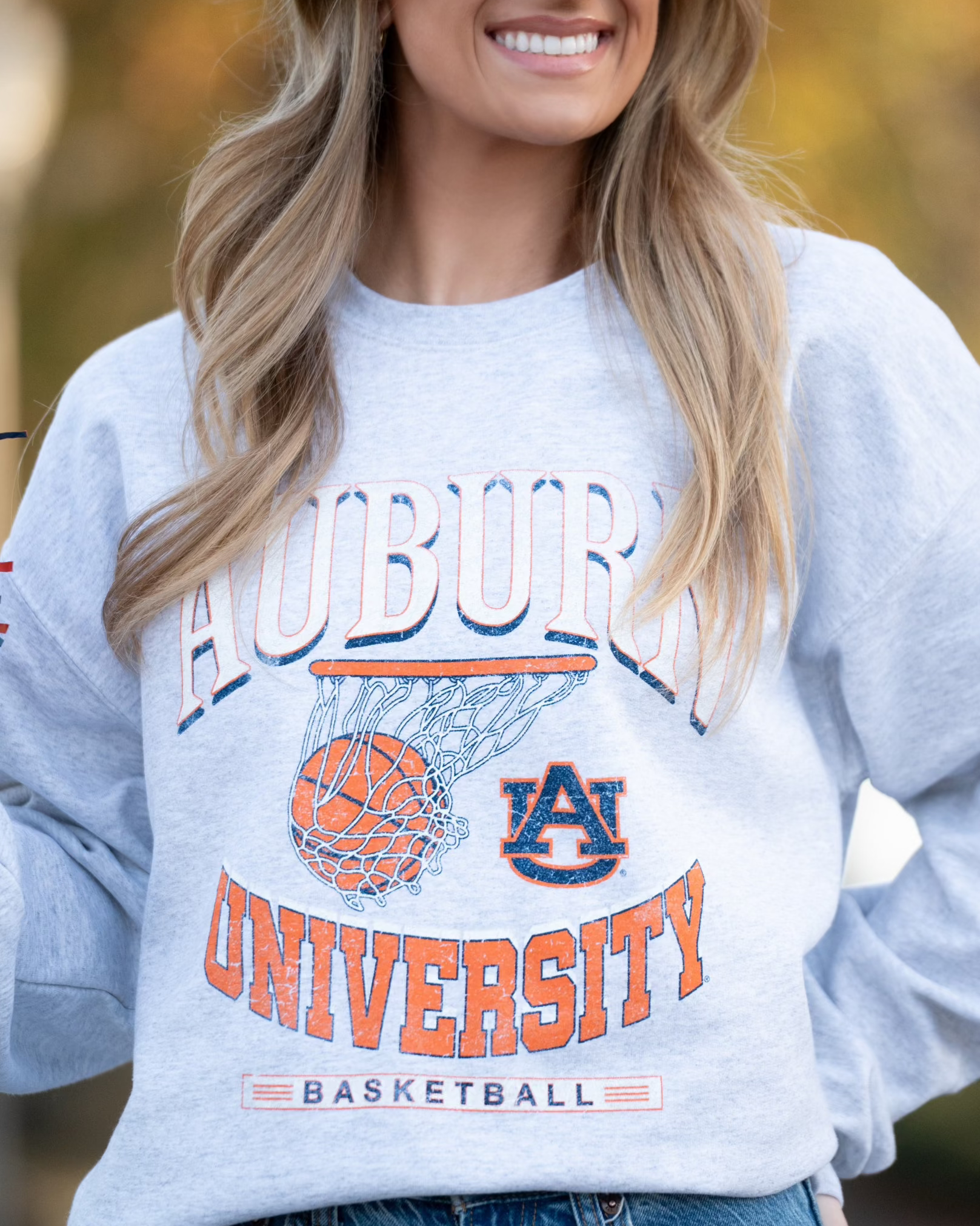 Auburn University Light Grey Heather Sweatshirt with a basketball landing in a hoop between text “Auburn” and “University Basketball”
