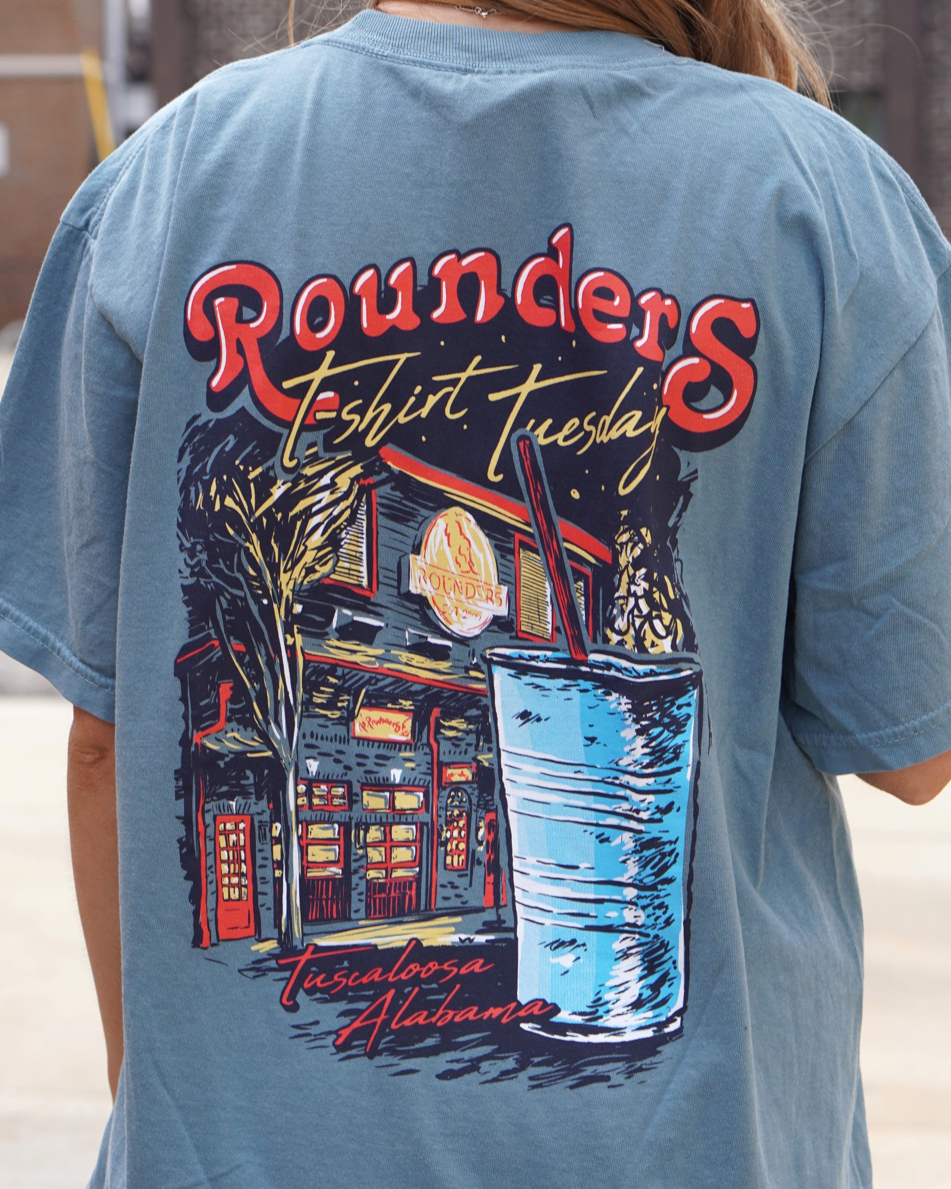 Rounders Blue T-Shirt with text "Rounders T-shirt Tuesday" above the Rounders Building and a Blue drink