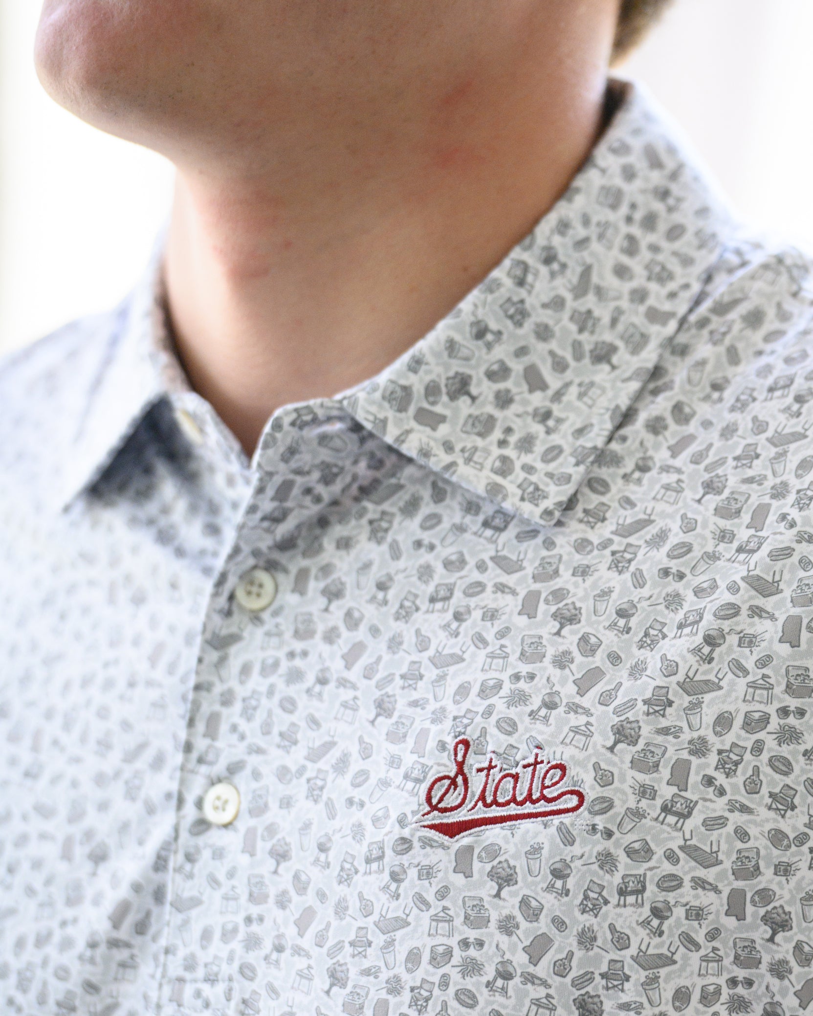Mississippi State Grey Men’s Patterned Polo with a tailgate themed pattern and the Script State Logo embroidery