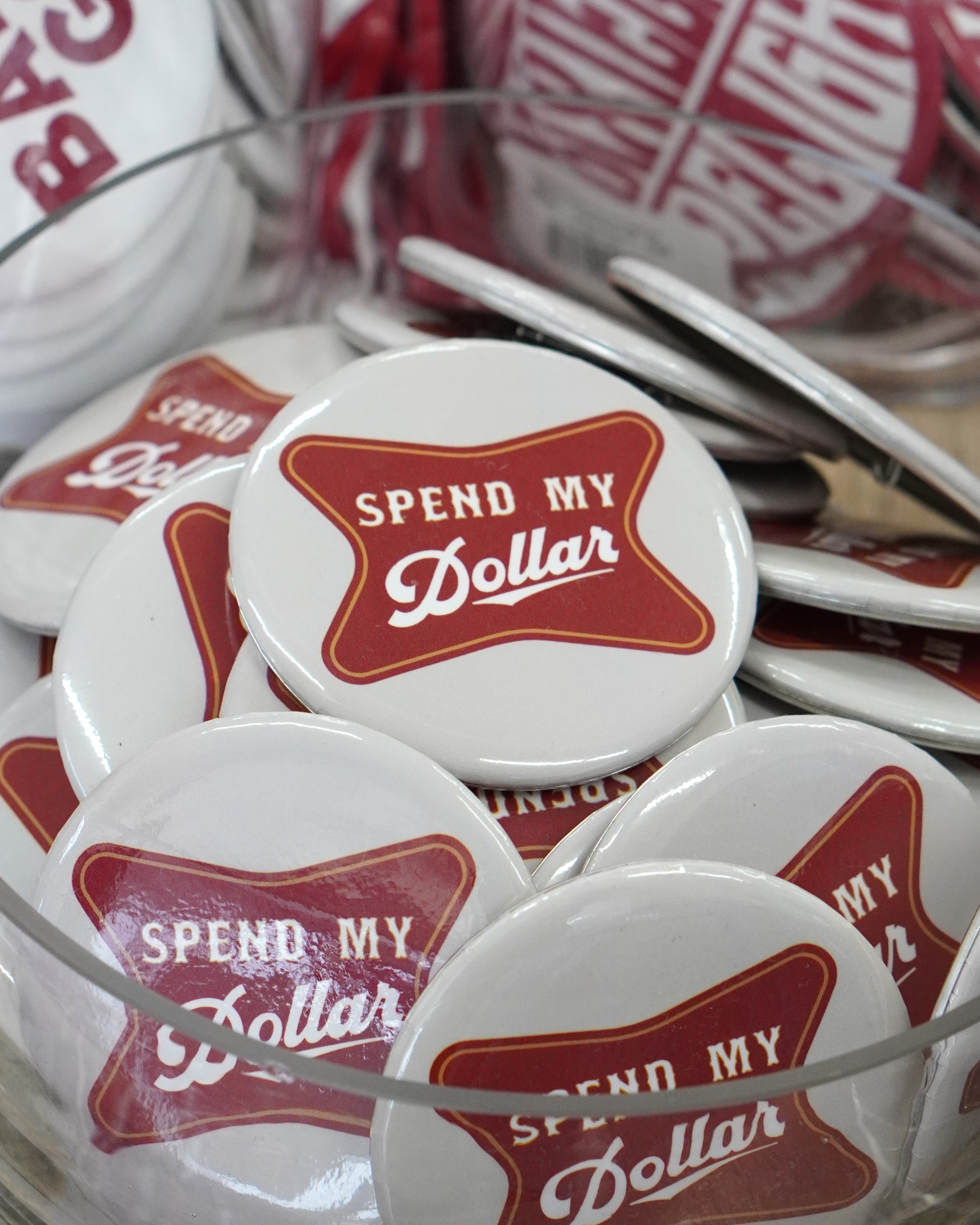 University of Alabama White Gameday Button featuring a Red sign with White text "Spend My Dollar"