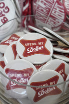 University of Alabama White Gameday Button featuring a Red sign with White text "Spend My Dollar"