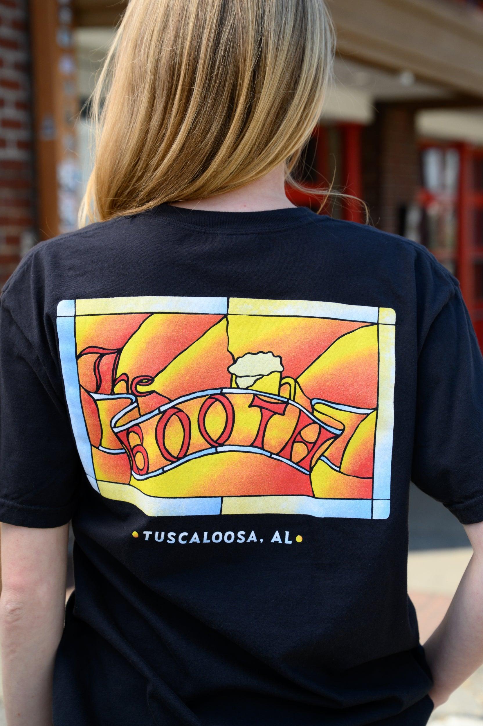 The Booth Black T-Shirt with a stained-glass style graphic featuring a banner with text “The Booth” and a mug of beer