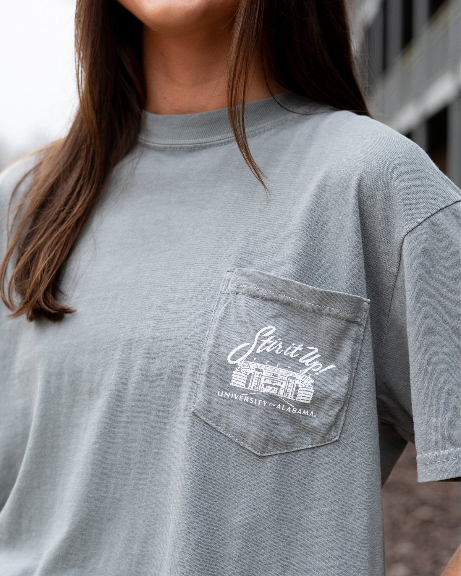 University of Alabama Grey T-Shirt Pocket Design with White text “stir it up” over the Bryant-Denny Stadium