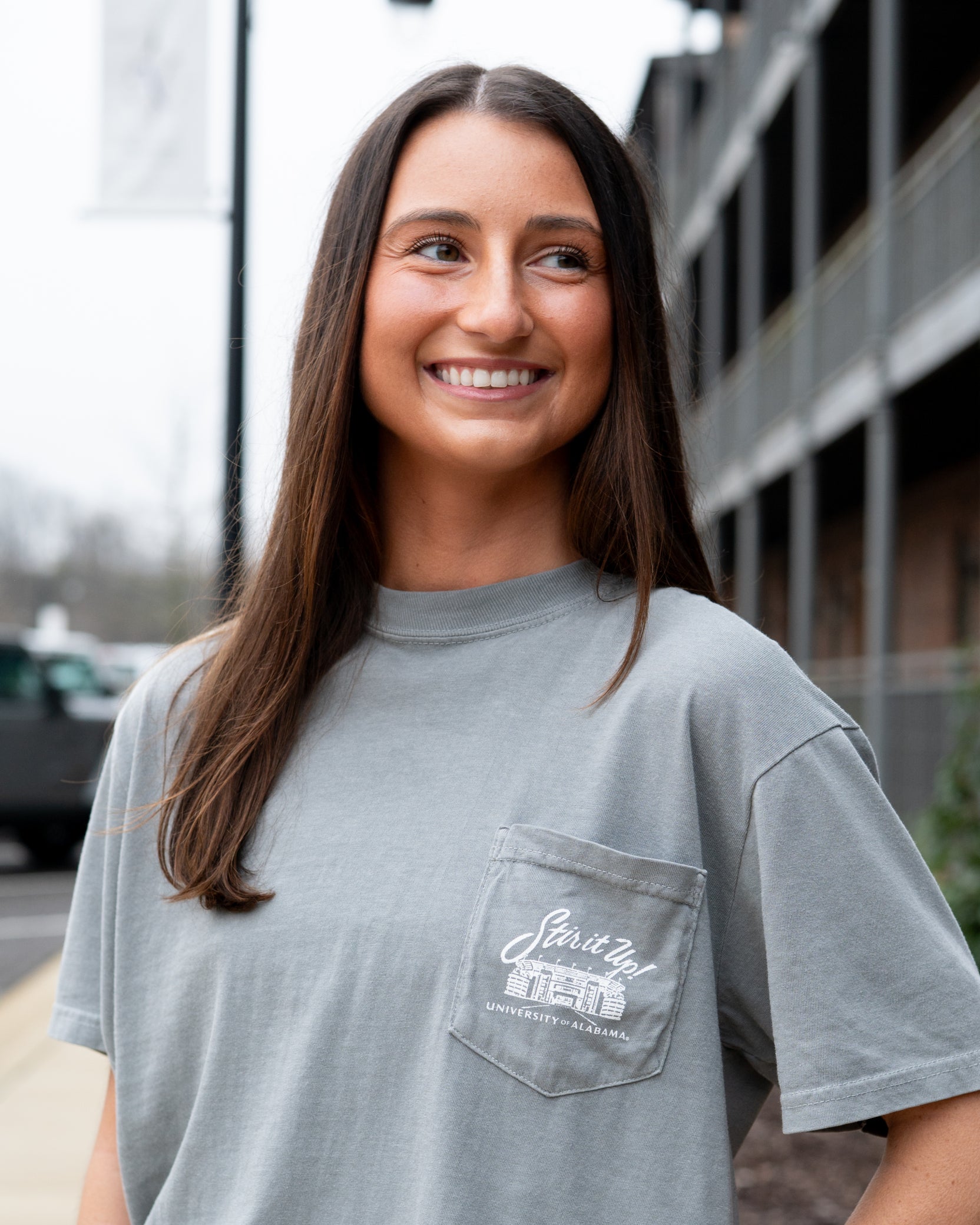University of Alabama Grey T-Shirt Pocket Design with White text “stir it up” over the Bryant-Denny Stadium