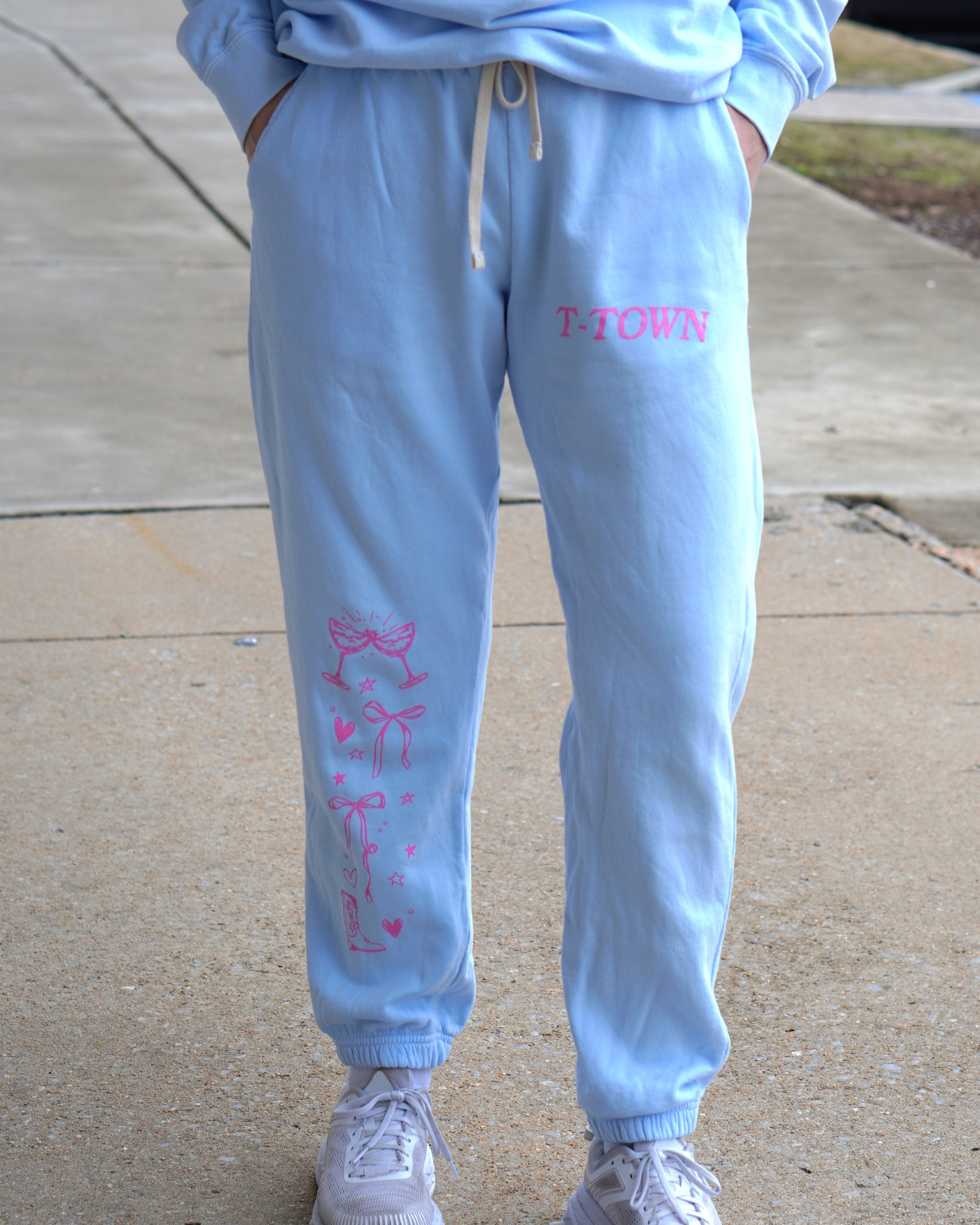 Light Blue T-Town Lifestyle Ladies' Sweatpants with Pink bows hearts, and stars surrounding Pink text "T-TOWN”