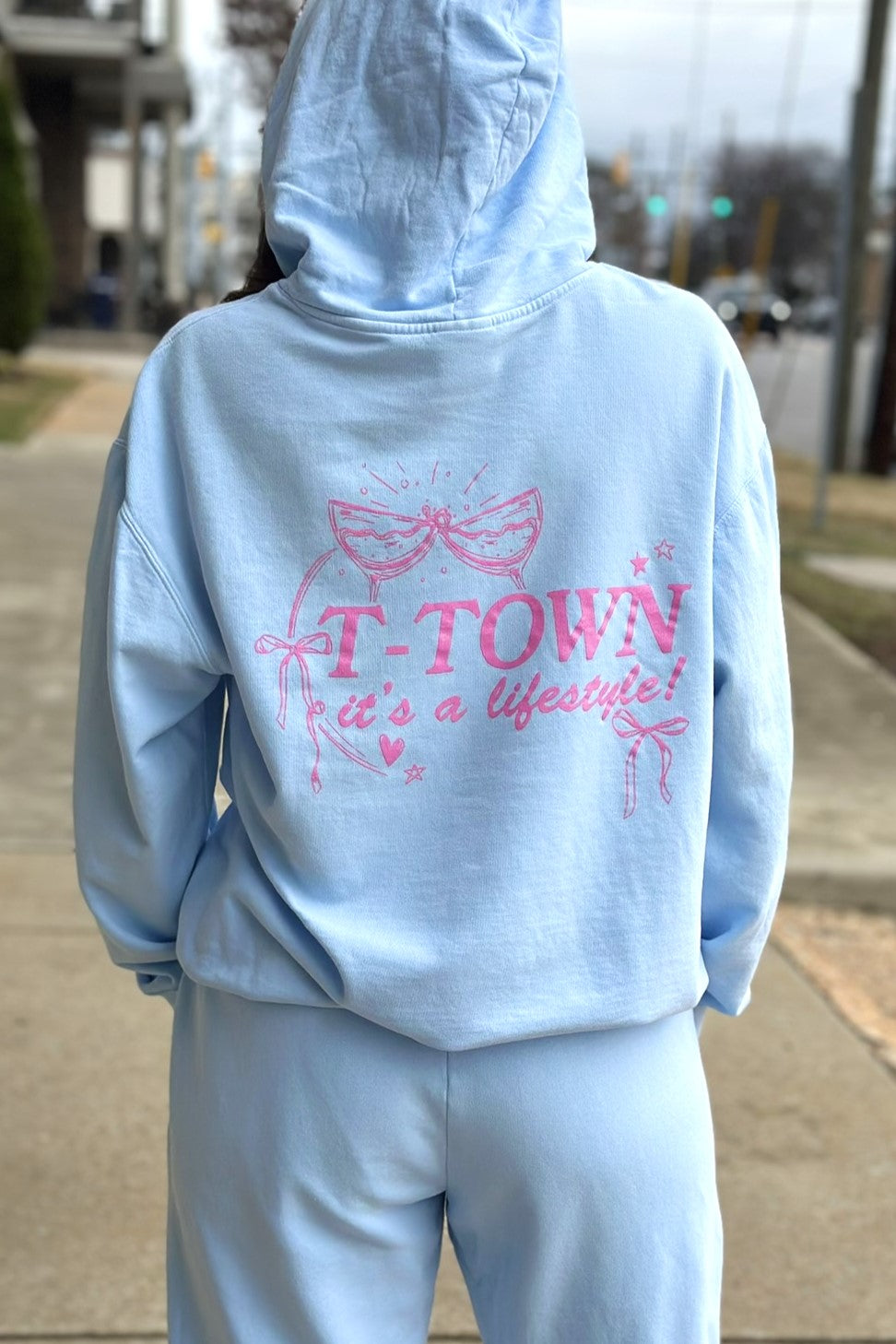 Light Blue T-Town Lifestyle Ladies' Hoodie with Pink bows hearts, and stars surrounding Pink text "T-TOWN it's a lifestyle!"