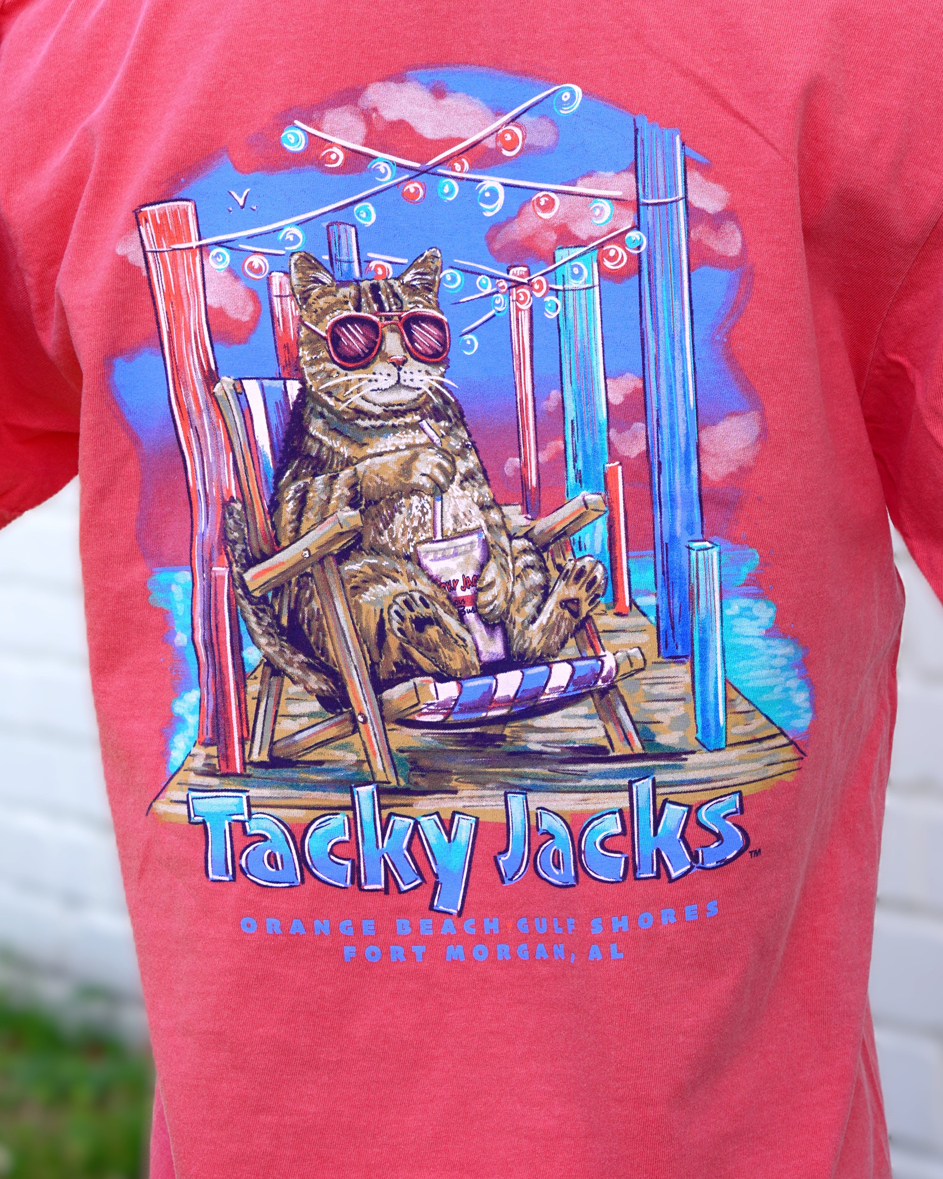 Tacky Jacks Watermelon T-Shirt with an image of a brown tabby cat wearing pink sunglasses and enjoying a drink on a pier above text "Tacky Jacks"