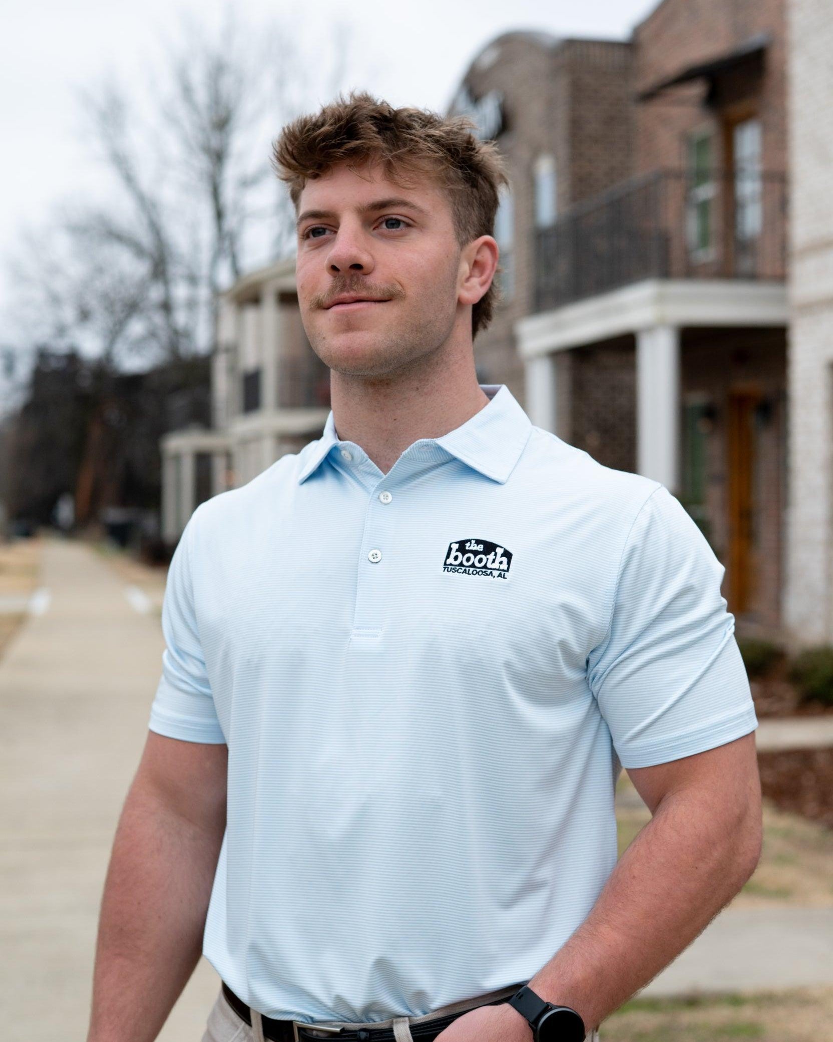 The Booth Light Blue Stripe Men’s Polo with The Booth Logo embroidered on the chest