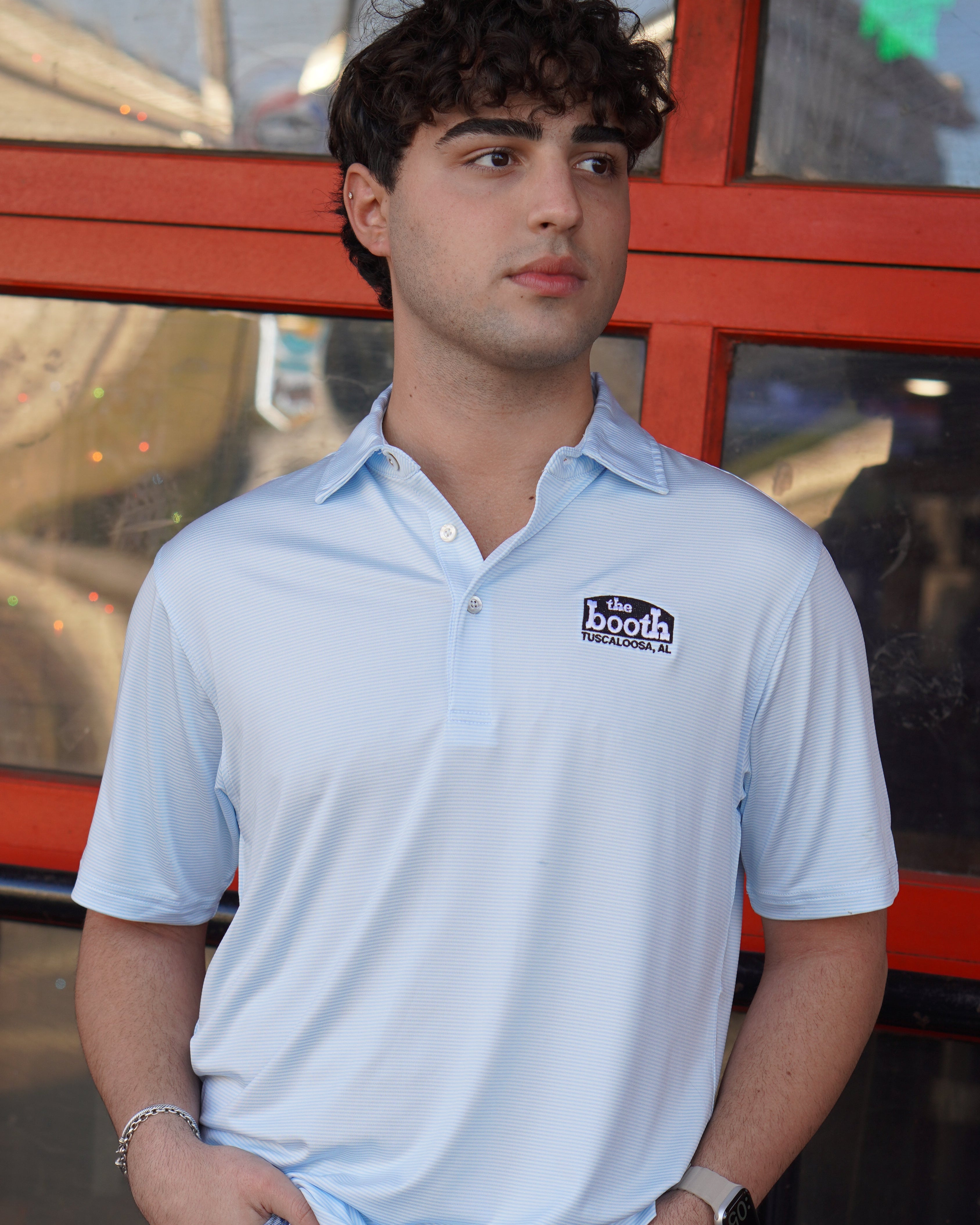 The Booth Light Blue Stripe Men’s Polo with The Booth Logo embroidered on the chest
