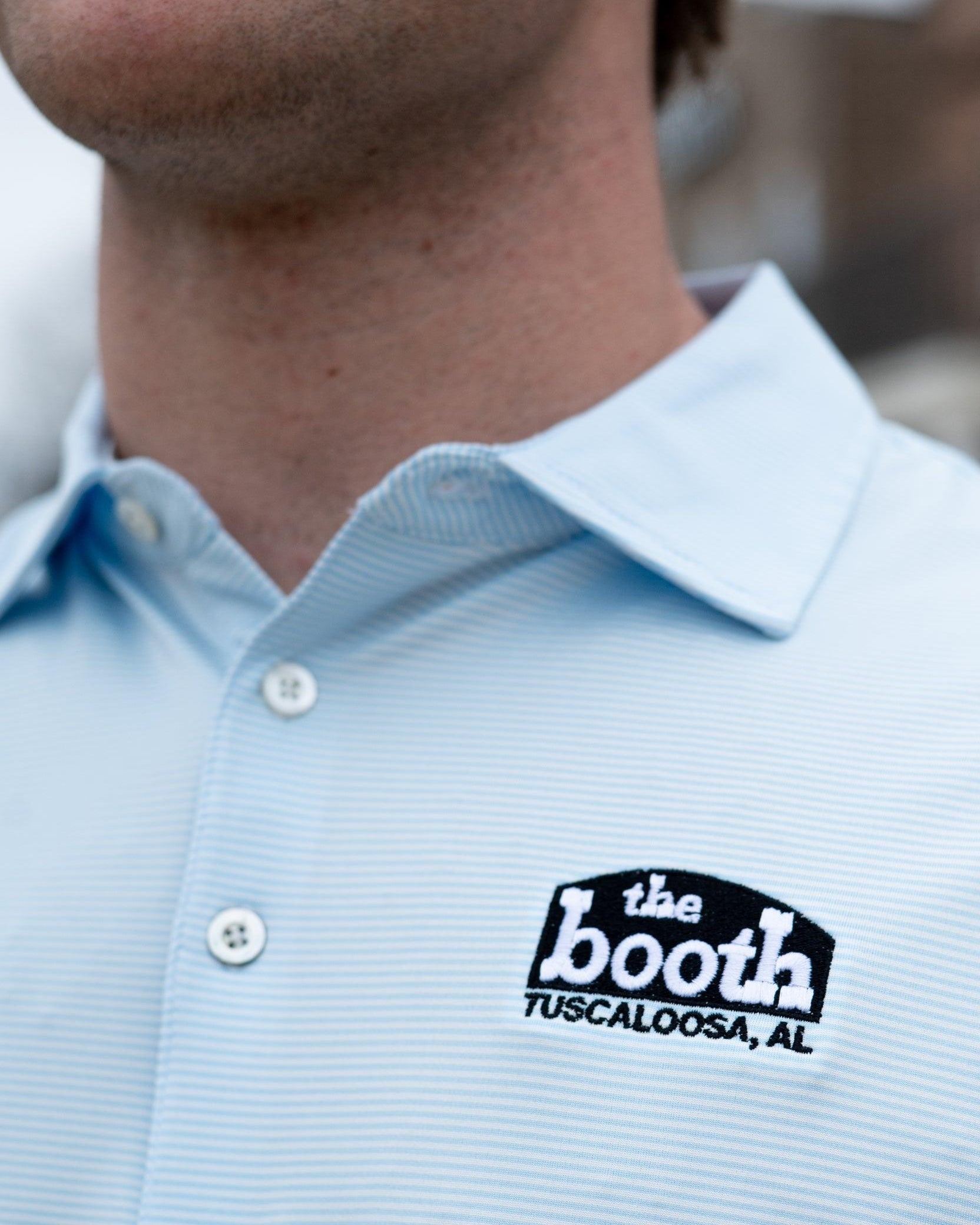 The Booth Light Blue Stripe Men’s Polo with The Booth Logo embroidered on the chest