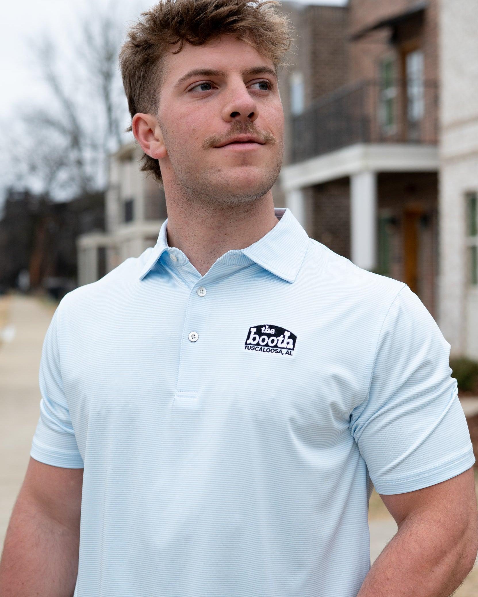 The Booth Light Blue Stripe Men’s Polo with The Booth Logo embroidered on the chest