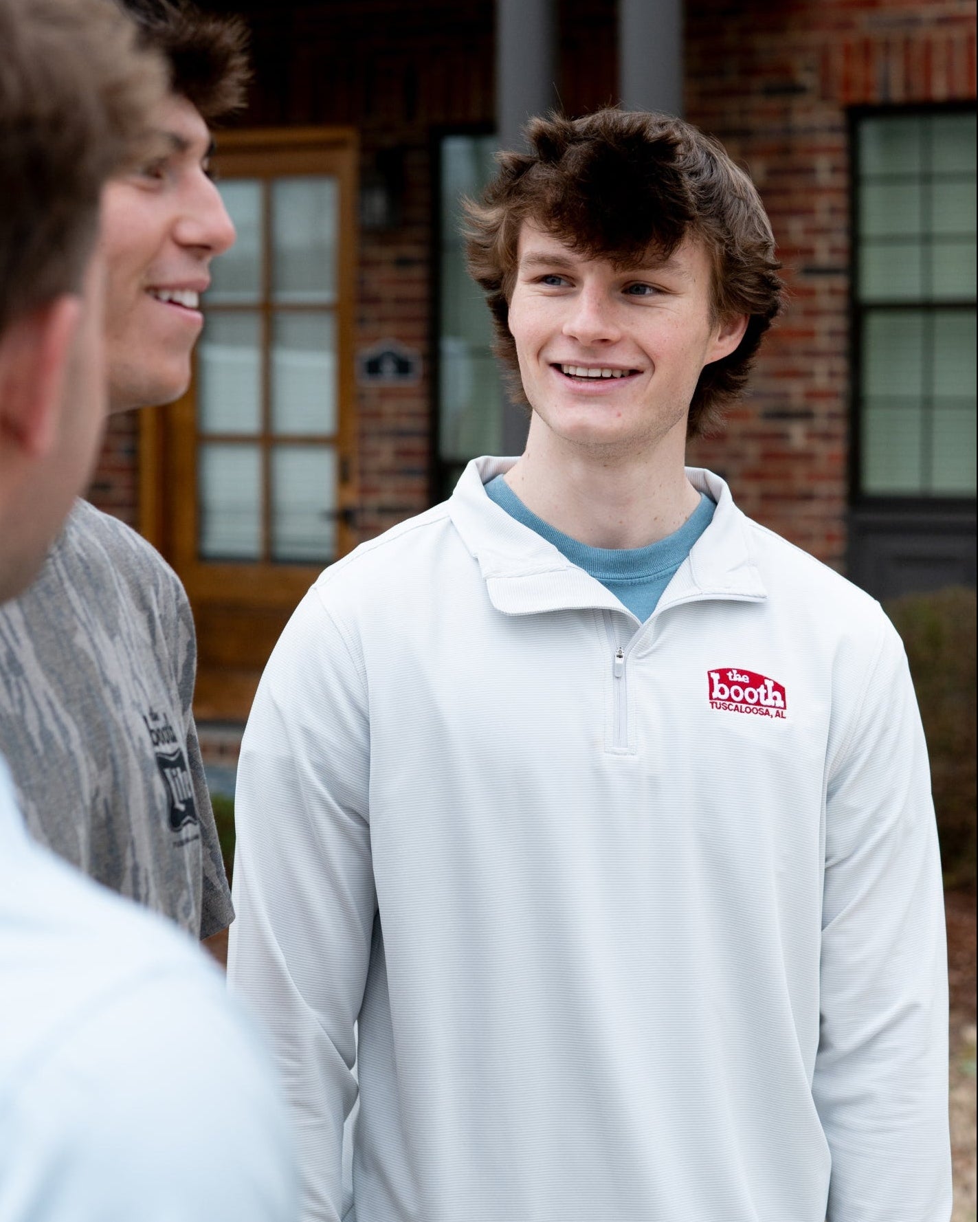 The Booth Light Blue Stripe Men’s Pullover with a Red The Booth Logo embroidered on the chest