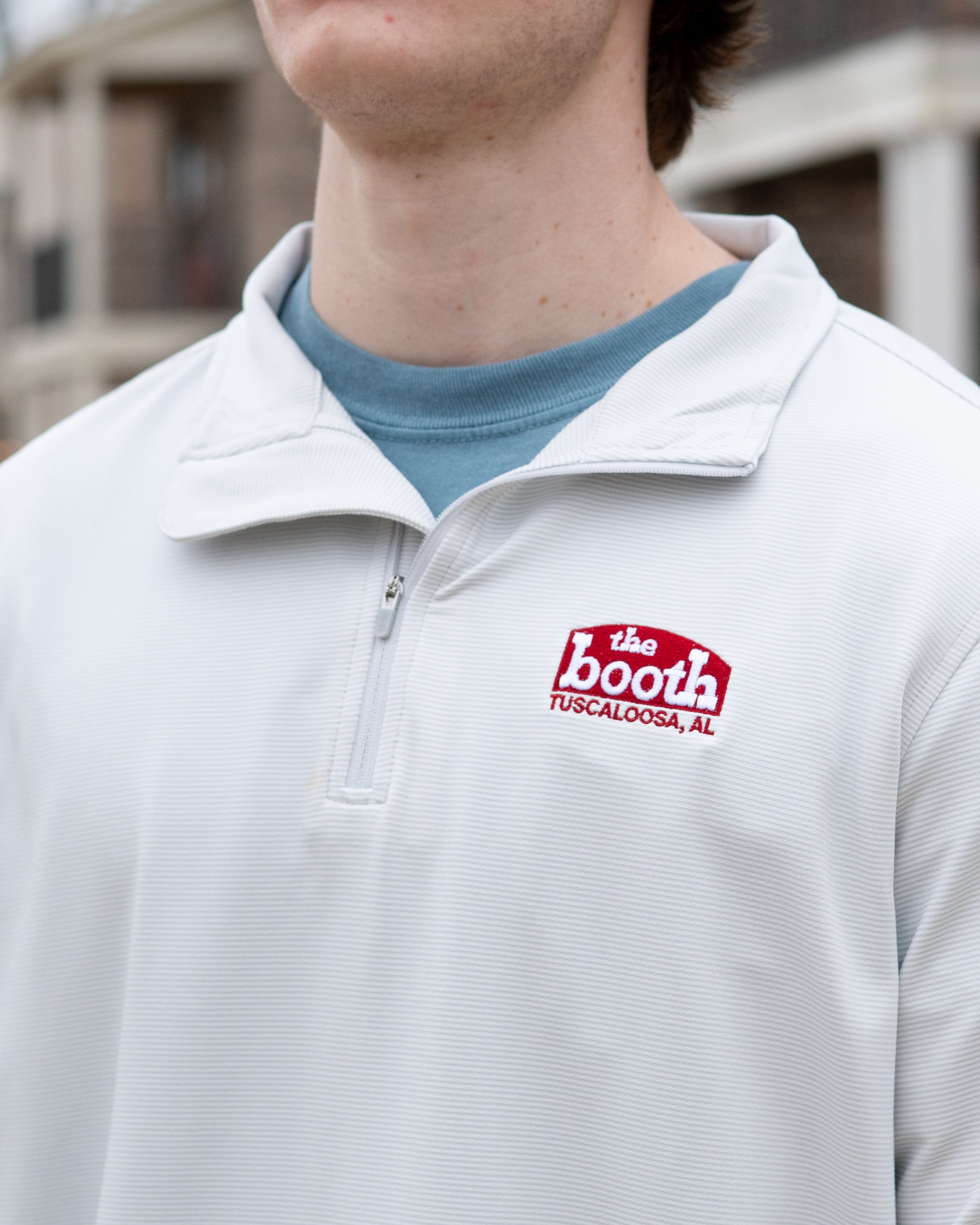 The Booth Light Blue Stripe Men’s Pullover with a Red The Booth Logo embroidered on the chest